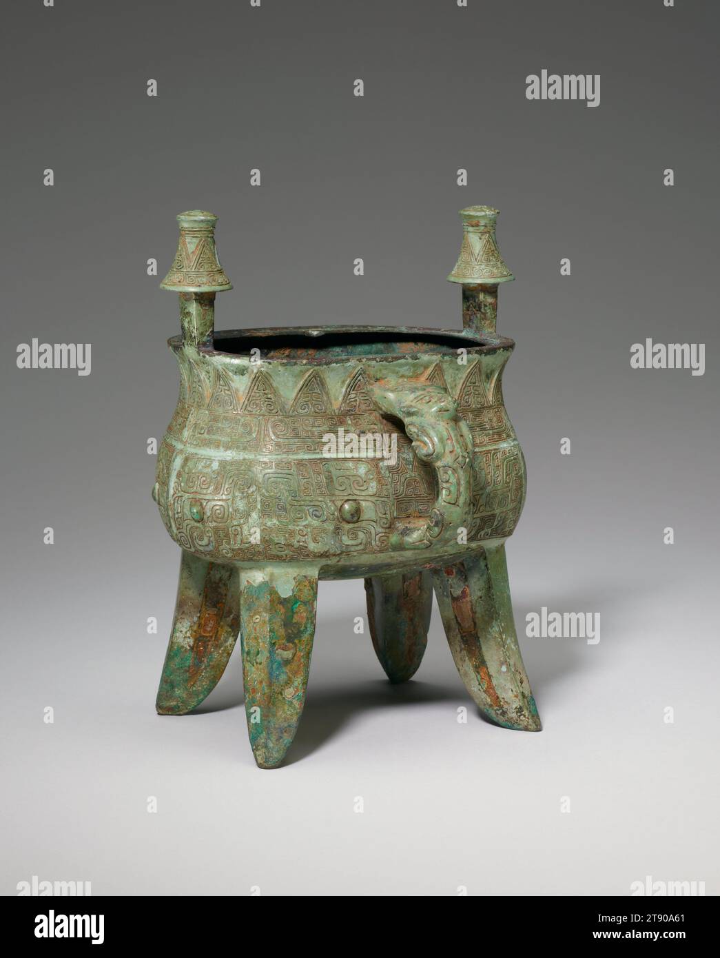 Jia wine vessel, 12th century BCE, 8 3/4 × 6 9/16 × 6 5/16 in., 4 lb. (22.23 × 16.67 × 16.03 cm, 1.8 kg)5 5/8 × 4 1/8 in. (14.29 × 10.48 cm) (object part, mouth), Bronze, China, 12th century BCE, The profile of this jia wine vessel’s body is S-shaped, with the inward curvature placed close to the rim of the vessel. Dragonized taotie and rising blades with stylized cicadas decorate the neck belt. The body taotie, on a ground of squared spirals, displays unusual features: horns with alternating T-shaped and straight scores usually associated with flanges, and a hybrid forehead shield Stock Photo