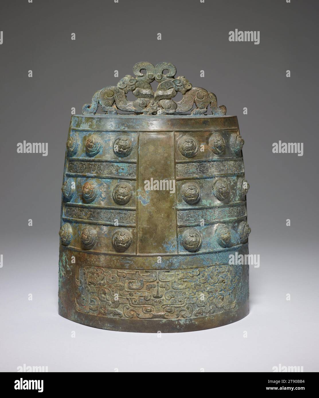Ritual bell, late 6th-early 5th century BCE, 12 1/2 x 9 1/2 in. (31.75 x 24.13 cm), Bronze, China, 6th-5th century BCE, This richly adorned bell was originally part of a graduated set. It is of the type po-cheng, one of two popular bell shapes encountered in Eastern Chou dynasty burials. Po-cheng bells have a flat bottom, slightly convex sides, a suspension device often in the form of stylized animals, cast on top, and emit a single tone. The second basic type of bell is called yung-cheng. Stock Photo