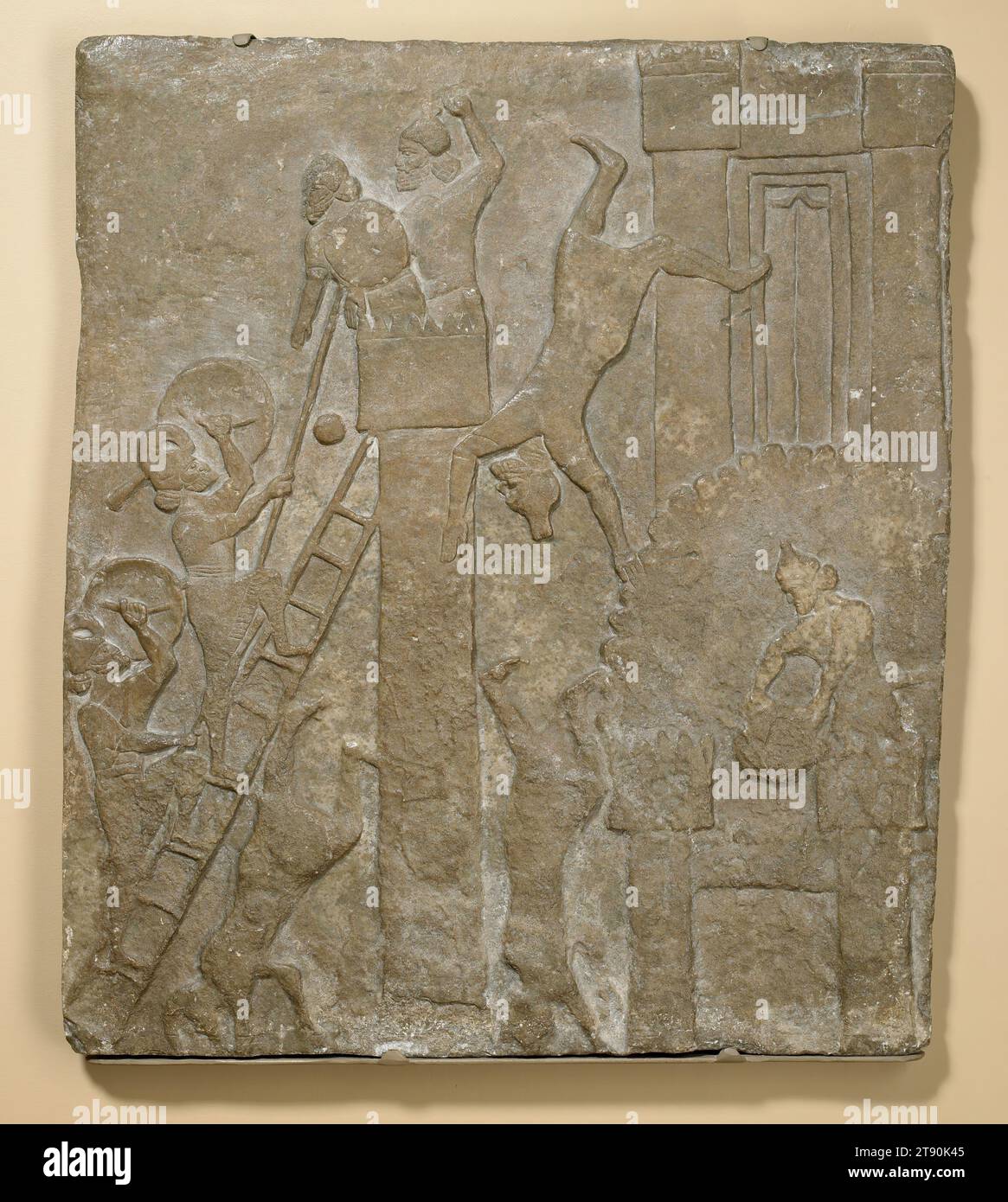 Bas-relief from Palace of Tiglath-Pileser III, 746–727 BCE, 38 5/8 in. (98.11 cm), Sandstone or gypseous alabaster, Iraq, 8th century BCE, This Assyrian relief of a city under siege comes from the palace of Tiglath-Pileser III at Nimrud. English archaeologist and diplomat Sir Austen Layard unearthed it during a mid-19th-century excavation. Two Assyrian soldiers mounting a ladder at the left attack the fortifications; one spears a man on a turret as an ally of the victim throws down stones. Two other soldiers are falling from the towers of the upper and lower gates on the right Stock Photo