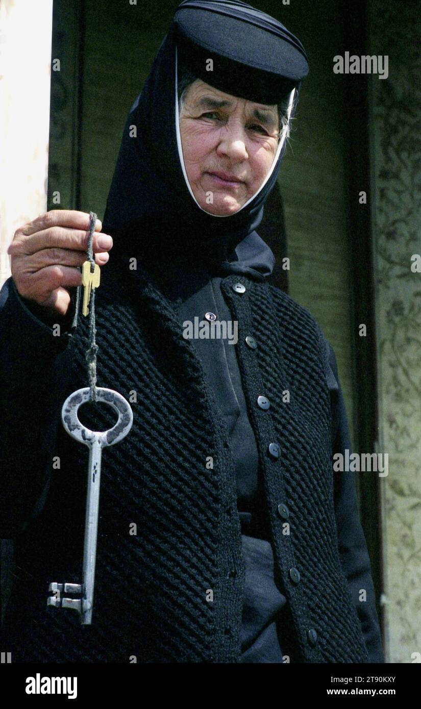 Prahova County, Romania. Nun at Ghighiu Monastery holding a large key. Stock Photo