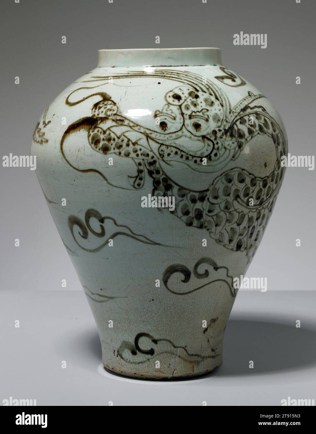 Jar with Dragon and Clouds, 17th century, Unknown Korean, 16 1/4 in. (41.28 cm), White porcelain with underglaze iron-brown, Korea, 17th century, In addition to designs painted in cobalt blue, Korean potters between the 1600s and 1800s produced many porcelain objects decorated with underglaze iron brown-designs. Possibly because cobalt was an expensive material, blue-and-white vessels tend to be carefully painted. In contrast, Korean potters display a remarkable freedom in their iron-brown designs. Here, a dragon with a humorously long snout coils around the swelling sides of this robust jar Stock Photo