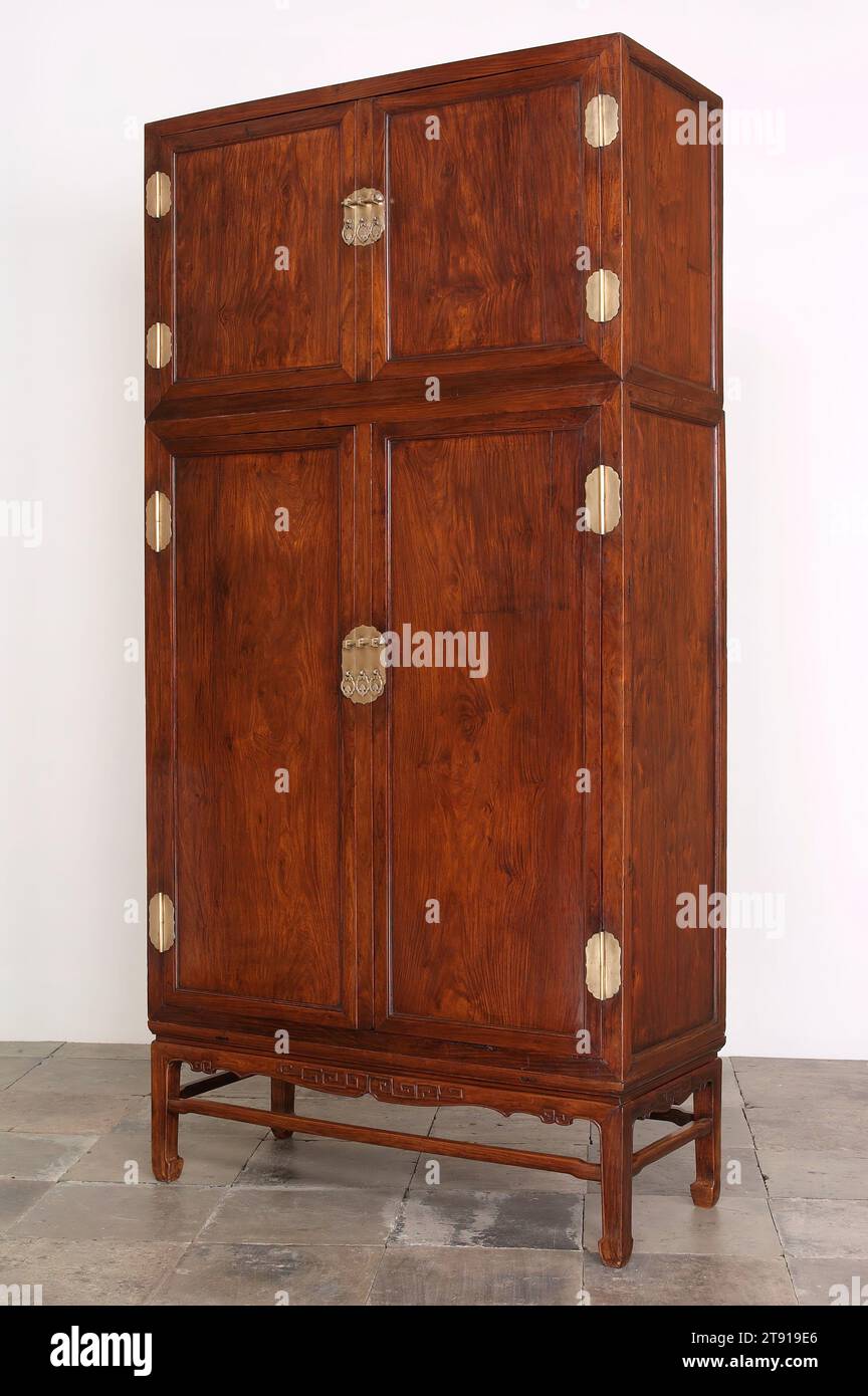 Compound Wardrobe Cabinet, one of a pair, early 18th century, 98 1/4 x 49 x 21 7/8 in. (249.6 x 124.5 x 55.6 cm) (assembled), Huang-hua-li hardwood and baitonghardware, China, 18th century, The largest form of Chinese cabinet is the monumental, square corner compound wardrobe. Always made in pairs, the form consists of a tall, lower unit surmounted by a shorter upper unit or 'hat chest' constructed from the same materials. These cabinets were designed primarily for the storage of fine garments which were folded and laid flat rather than hung. Stock Photo