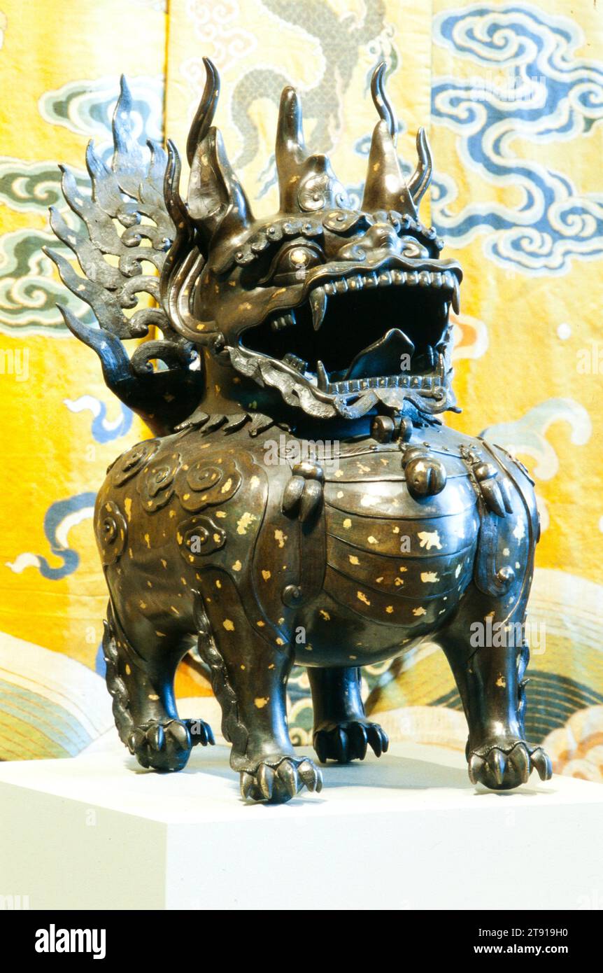 Temple Lion Censer, one of a pair, 17th century, 22 1/2 x 13 x 24in. (57.2 x 33 x 61cm), Bronze with splashed gold décor, China, 17th century, Resembling guardian lions, these auspicious beasts (luduan), each with a single horn, are mythical animals credited with the ability of distinguishing between good and evil. Pairs of these legendary animals were used to flank the imperial thrones throughout the Forbidden City, where they served as symbols of royal dignity, virtue, and wisdom. The separately cast heads are hinged allowing for the burning of incense in the hollow case bodies Stock Photo