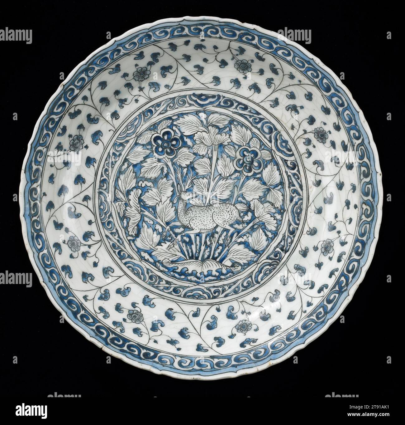Plate, early 18th century, 2 1/2 x 15 1/2 in. (6.35 x 39.37 cm), White earthenware with underglaze blue and black decor, Meshed ware, Iran, 18th century, Although blue-and-white patterns in ceramics are associated with China, Islamic potters were the first to use cobalt-blue decoration. When commercial ties to China were reestablished during the 1300s, fine ceramics imported from East Asia, particularly blue-and-white, became extremely popular and greatly affected subsequent Islamic styles. This outstanding example from the Safavid period is closely related to Chinese porcelains Stock Photo