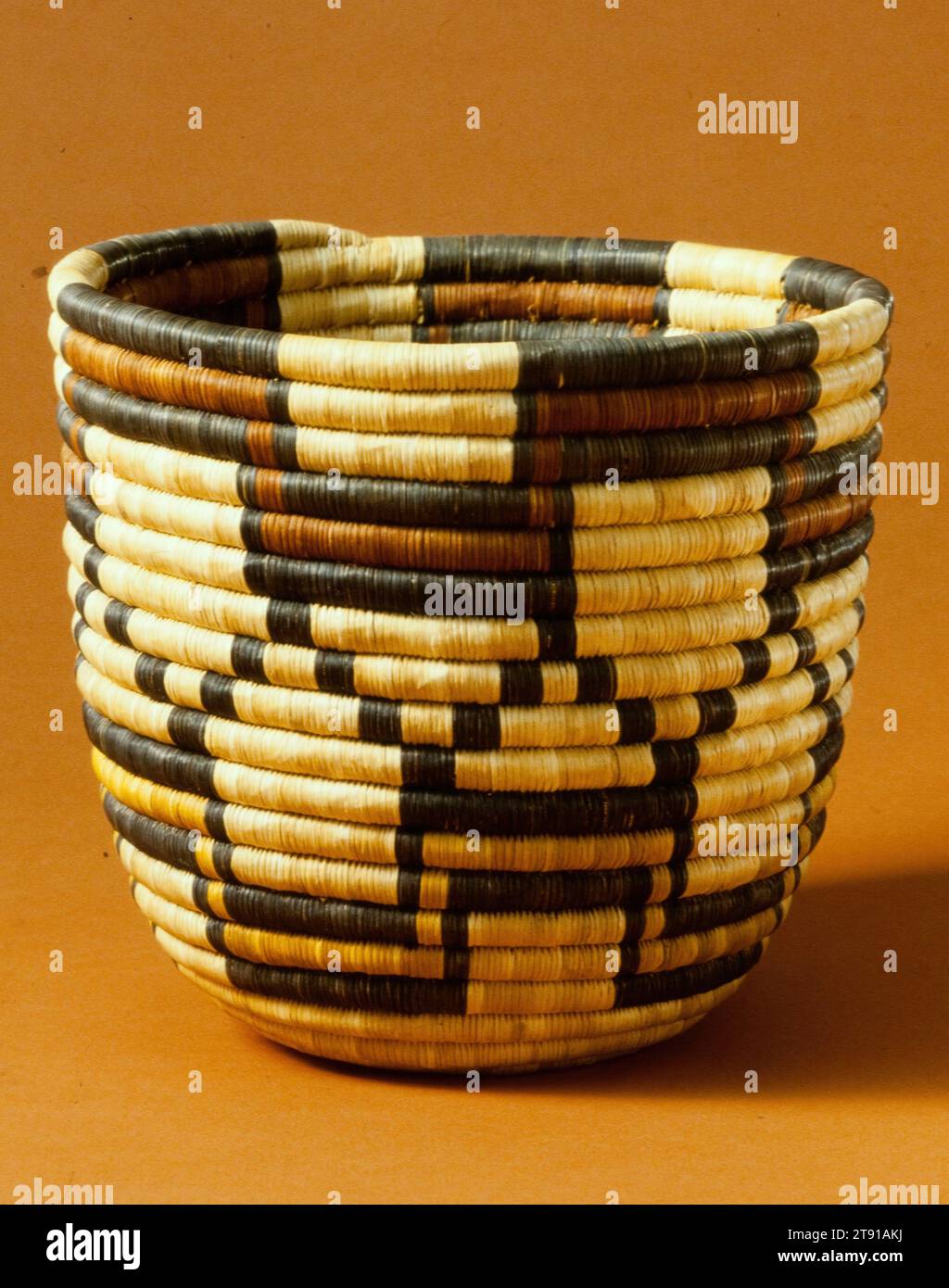 Basket, c. 1930, 9 3/8 x 9 3/4 x 9 3/4 in. (23.81 x 24.77 x 24.77 cm), Coiled grass, yucca fibers, United States, 20th century, The exact history of the development of Hòpituh Shi-nu-mu basketmaking remains vague, however modern artists have come to be considered one of the foremost basketmaking groups in North America. Their baskets employ the technique of sewing slender yucca splints wound tightly and stitched so closely that the stitches appear to be interlocked. Baskets were often created for sale Stock Photo