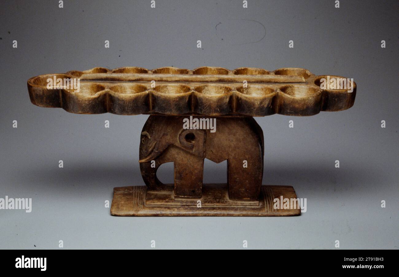 Mankala game board, 20th century, 10 1/2 x 24 x 7 1/4 in. (26.7 x 61.0 x 18.4 cm), Wood, Ghana, 20th century, Mankala is probably the oldest game in the world. Played throughout Africa and the Middle East, it is known by hundreds of different names, and there are many variations of the rules. In all versions two players move stones or seeds through a series of cups, trying to capture the most pieces. Although the game seems simple, it involves mathematical and strategic calculation and can be as complex and challenging as chess Stock Photo