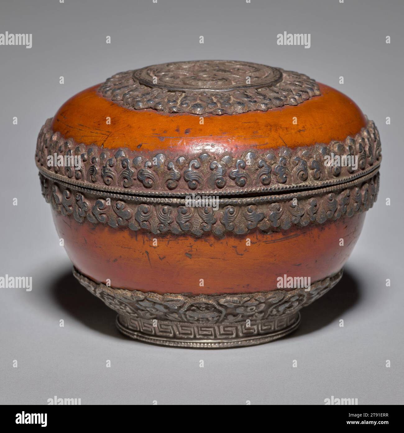 Prayer beads and box, late 19th century, 3 5/16 x 4 3/16 in. (8.41 x 10.64 cm), Burlwood and silver, Tibet, 19th century, In Tibetan Buddhism, prayer wheels are akin to rosaries, imbued with a powerful belief in the meditative repetition of sacred syllables, sounds, and prayers. A prayer surrounds the silver cylinder, while inside is a long, tightly rolled paper scroll printed with prayers and invocations. As the wheel spins with the aid of a suspended weight, the printed prayers are 'sent out' with each revolution. The wheel’s rotation equates to the reading or reciting of each invocation Stock Photo