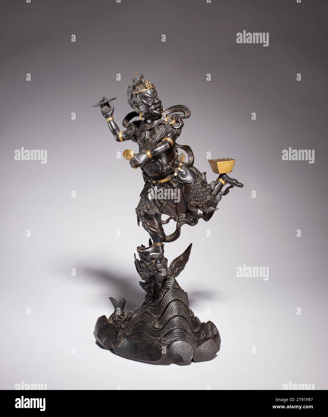 Kui Xing (God of Literature), 16th century, 25 x 7 x 5 in. (63.5 x 17.78 x 12.7 cm) (approximate), Bronze with traces of gilding, China, 16th century, Originating as a Daoist deity associated with the constellation Ursa Major, Kui Xing (also called Wen Chang and Wen Di) is worshipped in the third and eighth months as the God of Literature and patron saint of scholars. The surly-looking divinity is represented holding a brush in his right hand while standing on the head of a large fish becoming a dragon. The transformation of a carp into a dragon was a synonym for the literary success Stock Photo
