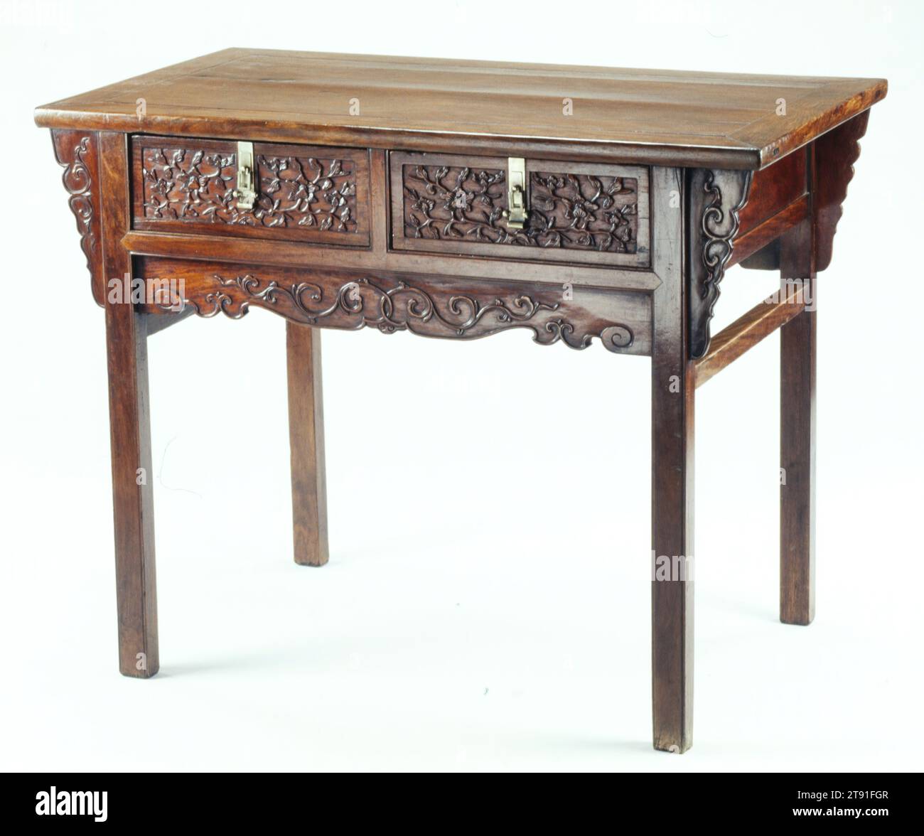 Two-Drawer Table, 17th century, 34 1/8 x 43 13/16 x 24 11/16 in. (86.68 x 111.28 x 62.71 cm), Huang-hua-li hardwood, China, 17th century, While useful for the storage of small items, recessed-leg tables with drawers do not appear often in late Ming woodcuts or paintings and relatively few have survived. The late Ming edition of the Lu Ban Ching carpenter's manual does, however, illustrate a woman using a two-drawer table like this one in combination with a mirror stand as a dressing table. The sumptuous carving of flowering plum branches on the drawer fronts is decoration Stock Photo