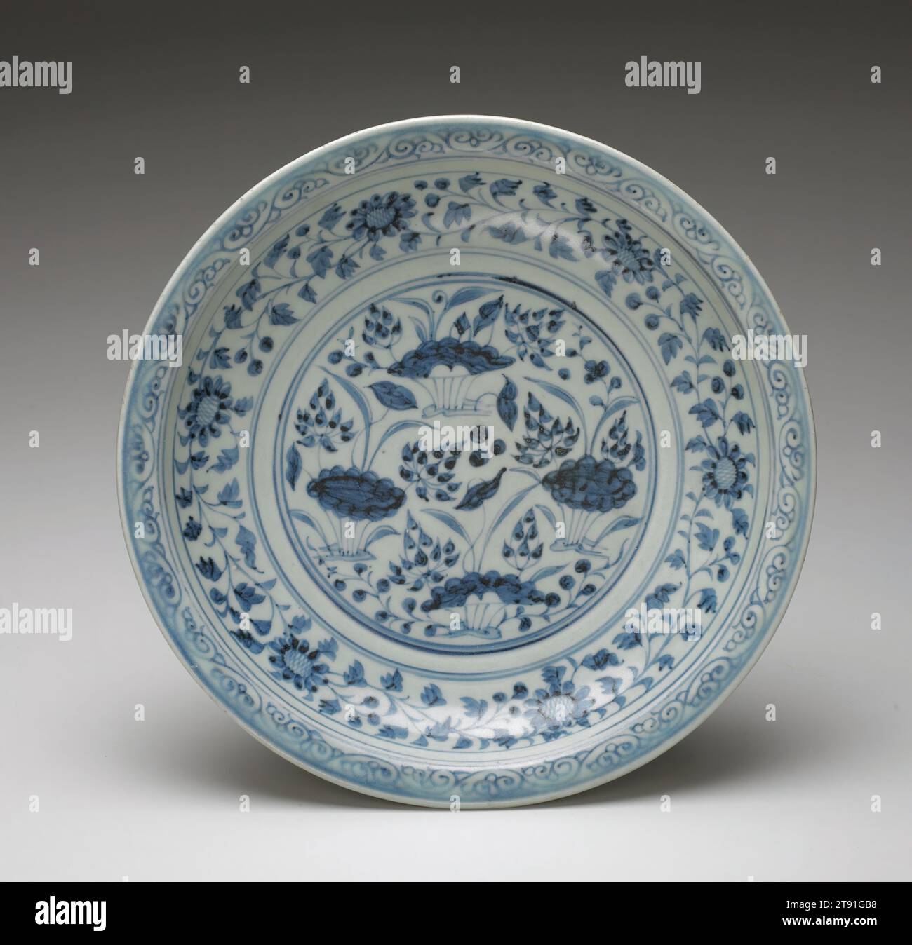 Dish, c. 1350, 2 1/16 x 11 5/16 x 11 5/16 in. (5.24 x 28.73 x 28.73 cm), Porcelain with cobalt blue décor under clear glaze, China, 14th century, Kubilai Khan, founder of the Yuan dynasty (1280-1368), established his capital at Peking and its magnificence soon attracted merchants and craftsmen from Asia and Europe. Trade was heavily promoted and the famous underglaze blue painted porcelain made at the great ceramic metropolis of Ching-te-chen in Kiangsu province, quickly gained popularity in the markets of Southeast Asia, the Middle East, and eventually Europe Stock Photo