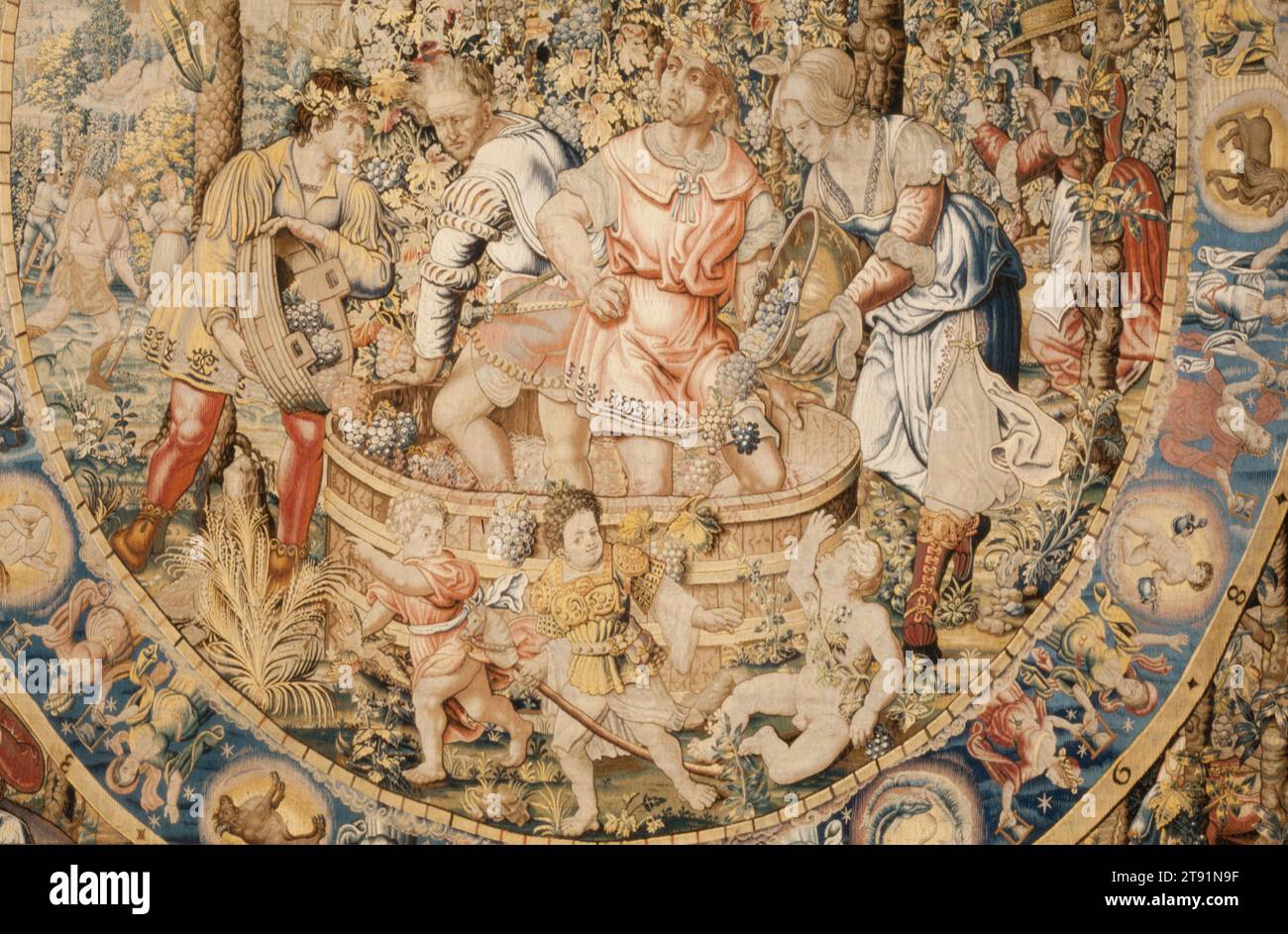 Month of September, 1525-1528, Circle of Bernard van Orley; Designer: Circle of Bernard van Orley, Flemish, active 16th century, H.177-3/4 x W.166-3/4 in. (irregular), Silk, wool; tapestry weave, Belgium, 16th century, September is represented here by a grape harvest and wine making. Bacchus, the Roman god of wine, red-nosed from drinking, oversees the crushing of grapes. His mother, Semele (labeled semela), and father, Jupiter (iupiter), appear in the upper corners. In the oval band framing the main scene, the twelve signs of the zodiac alternate with twelve pairs of women holding hourglasses Stock Photo