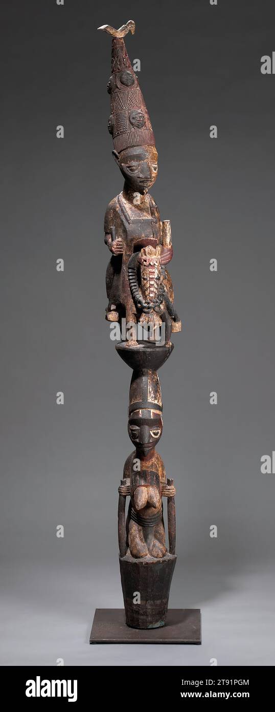 Ancestral Post, c. 1910, attributed to Adeshina, Nigerian, d. 1945, 65 1/2 x 8 3/4 x 11 1/2 in. (166.37 x 22.23 x 29.21 cm), Wood, pigment, metal, Nigeria, 20th century, Most of the African master carvers remain unidentified. But some artists are known, and are still remembered and celebrated today. Agbonbiofe, a member of the famous Adeshina carver family, is one of them. He made this post for a Yoruba royal palace, where it supported the roof of a veranda lining the king’s reception courtyard. The two-tiered composition depicts a mounted king wearing a conical crown Stock Photo