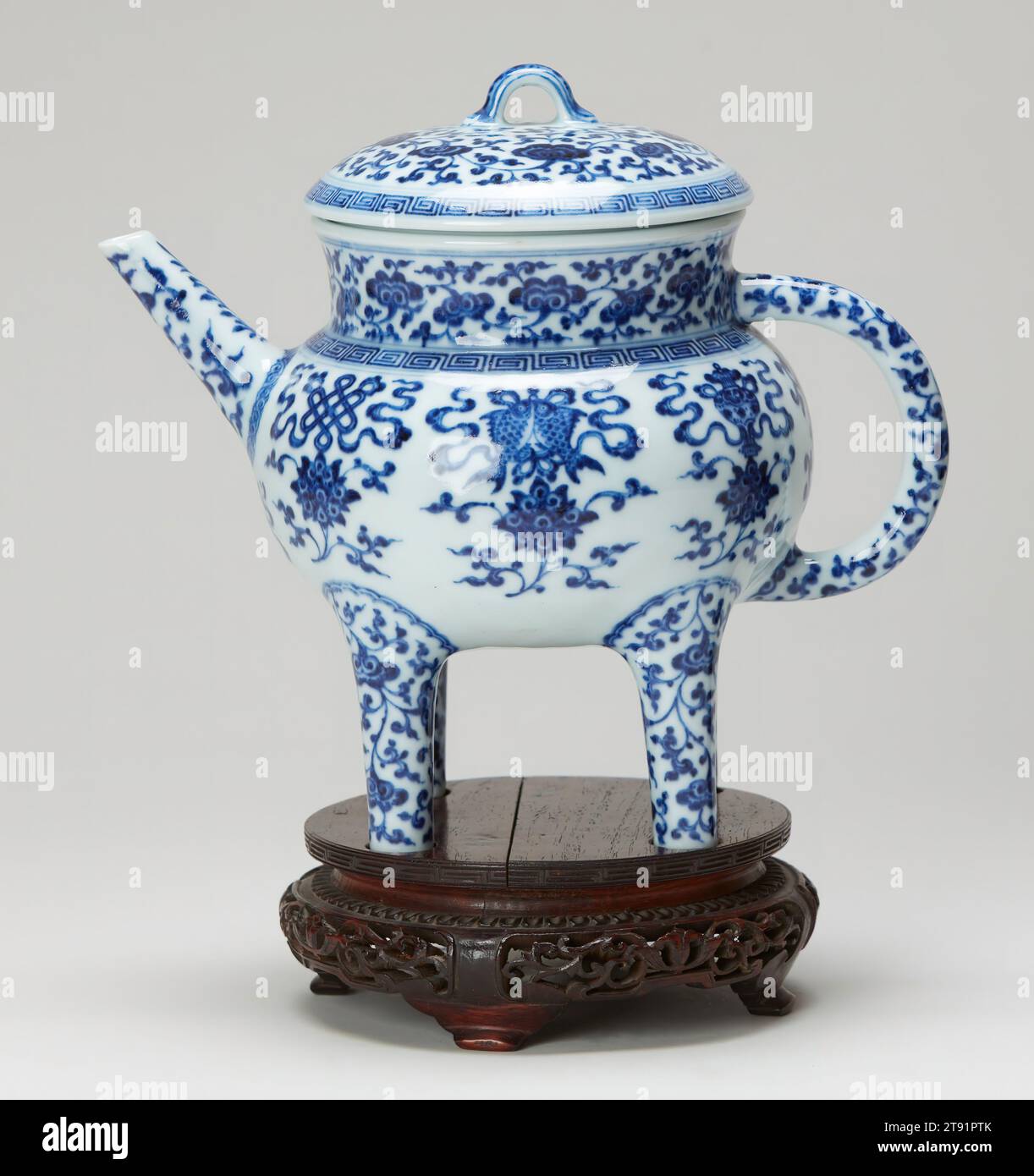 Ewer, 18th century, 8 3/4 x 9 1/4 x 6 1/8 in. (22.23 x 23.5 x 15.56 cm), Porcelain with cobalt blue decoration under a clear glaze, China, 18th century, This unusual four-legged covered ewer takes the general form of a type of ancient bronze wine vessel termed ho. The work is a fine example of the use of an ancient bronze shape in combination with designs painted in underglaze blue-and-white. The rare decorative pattern consists of numerous ling-chih fungus (the fungus of immortality) set against an overall tendril design. The eight Buddhist emblems Stock Photo