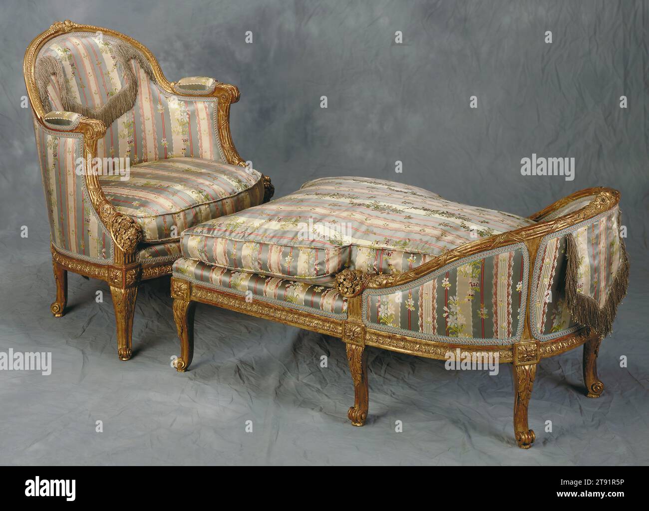 Duchesse d'enfant brisée (child’s chair), c. 1780, Georges Jacob, French, 1739–1814, 30 1/4 x 24 x 21 1/2 in. (76.84 x 60.96 x 54.61 cm), Wood, gilt (modern upholstery), France, 18th century, Georges Jacob, one of the foremost cabinet and chair makers in France in the last quarter of the 1700s, furnished the apartments of the nobility and the royal family of France. This elegant early Neoclassical daybed with its separate ottoman, stamped by Jacob on the frame, was probably commissioned for a child or a very small adult Stock Photo