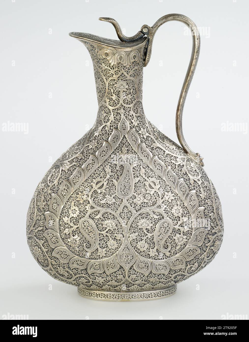Claret Jug, c. 1890, 9 1/4 x 6 3/4 x 4 in. (23.5 x 17.15 x 10.16 cm), Silver, India, 19th century, This highly embellished jug for claret, a French red wine, is a testament to an Anglo-Indian aesthetic. This style proved fashionable among British officers based on the subcontinent, Anglophile Indians, as well as markets abroad. The jug’s central motif features a tree sprouting three elongated mangos, a shape known on the subcontinent as kunj. In Europe, this motif is better known as 'paisley,' after the Scottish city of Paisley Stock Photo