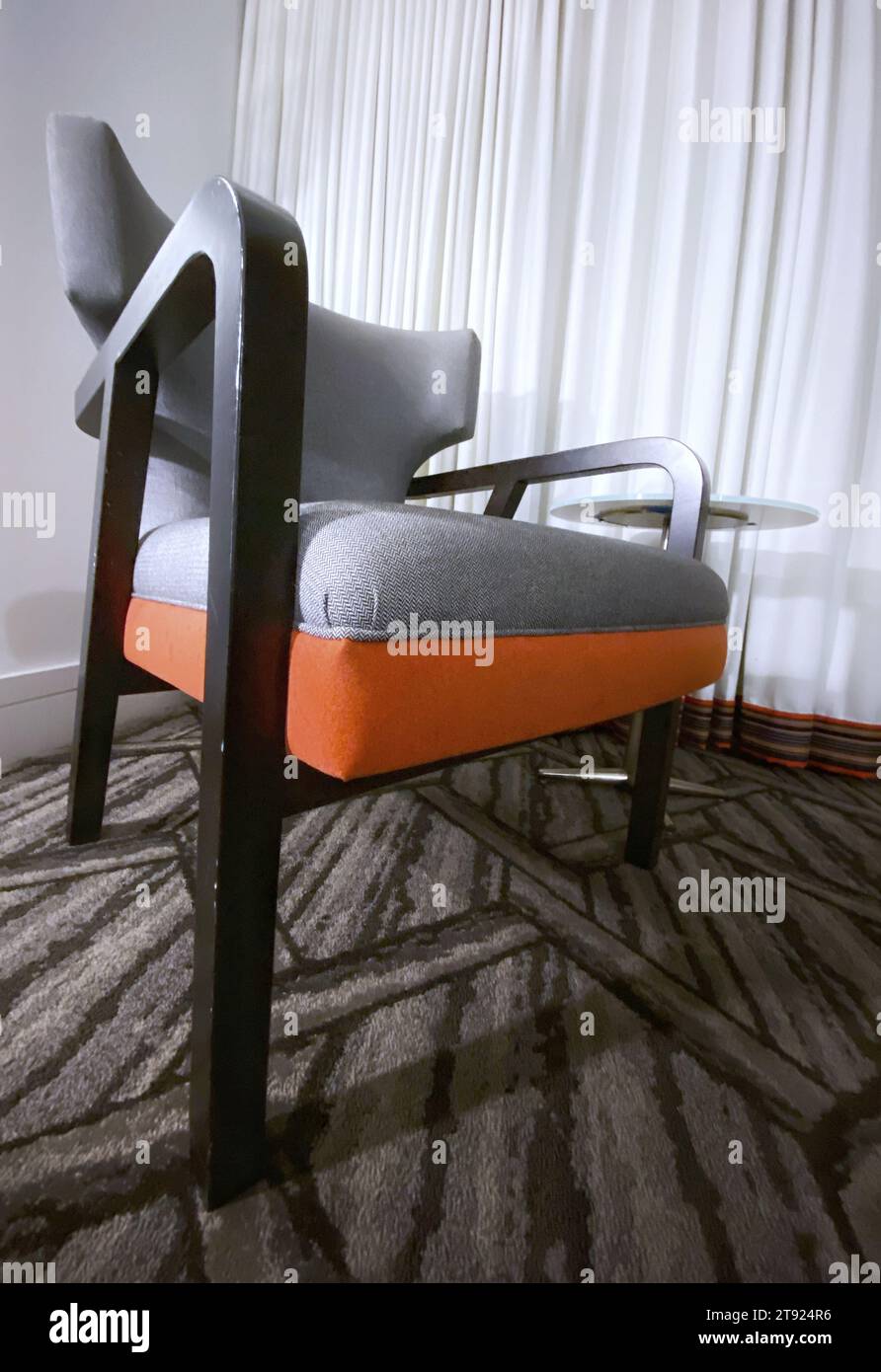 A stylish grey and orange chair in a modern hotel room Stock Photo