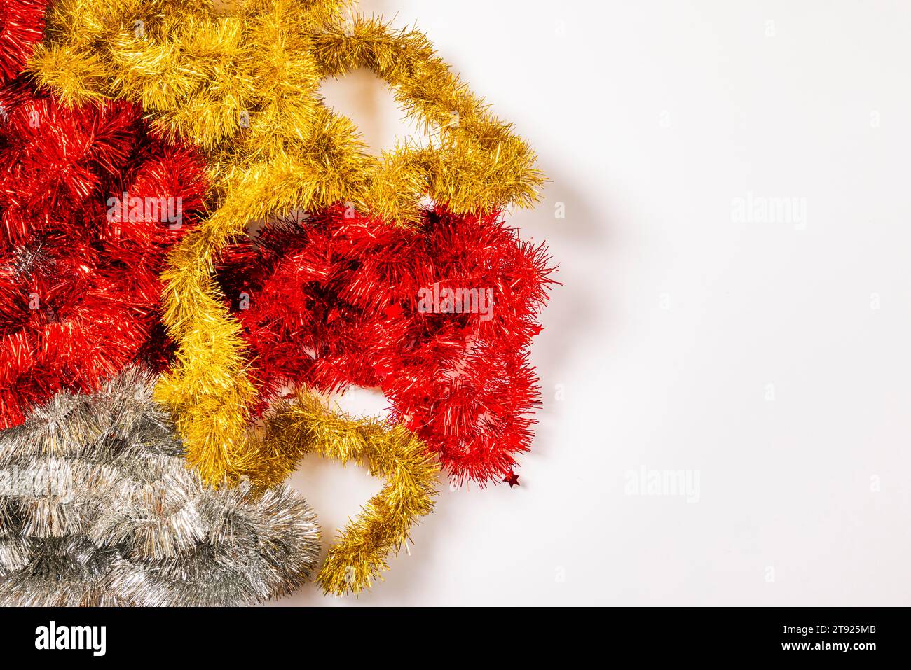 Tinsel garlands, gold, red, silver, white background, copy room Stock