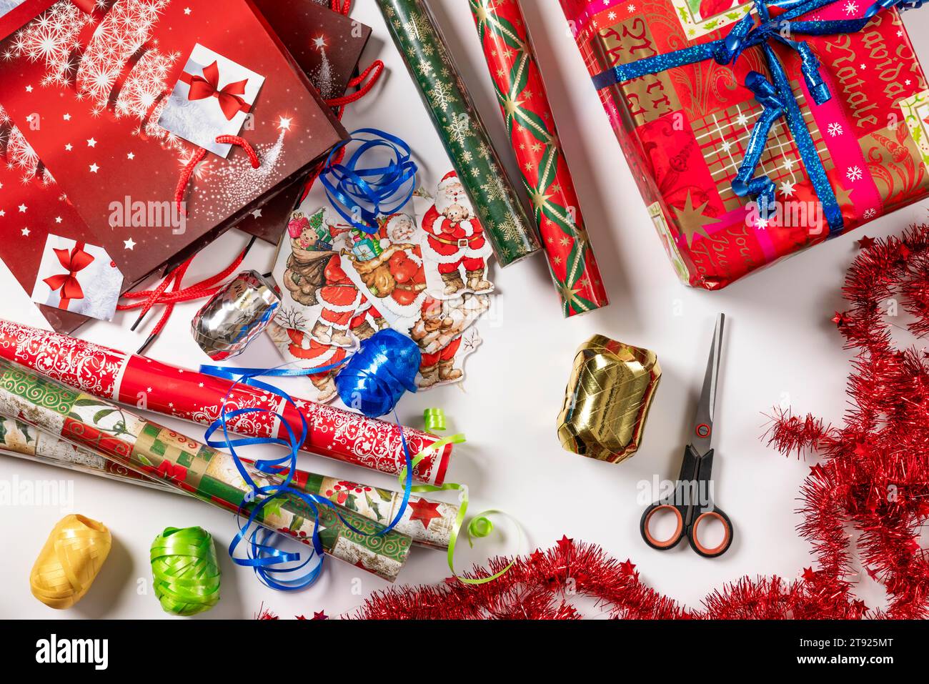 Gift wrapping, christmassy, gift bags, paper, tags, ribbon, scissors, white background Stock Photo