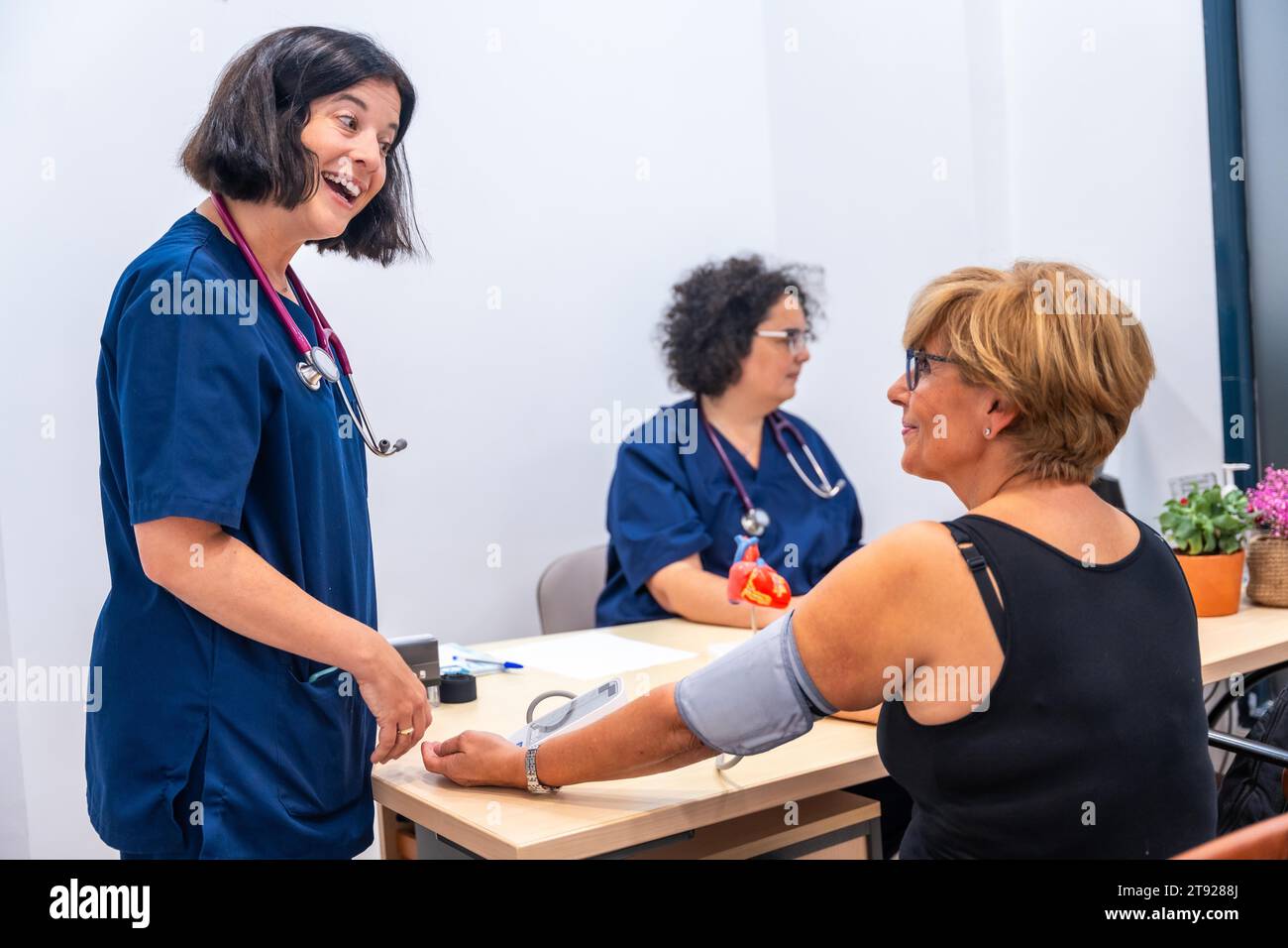 Cardiologist doctor in the cardiology clinic measuring a client's blood pressure Stock Photo