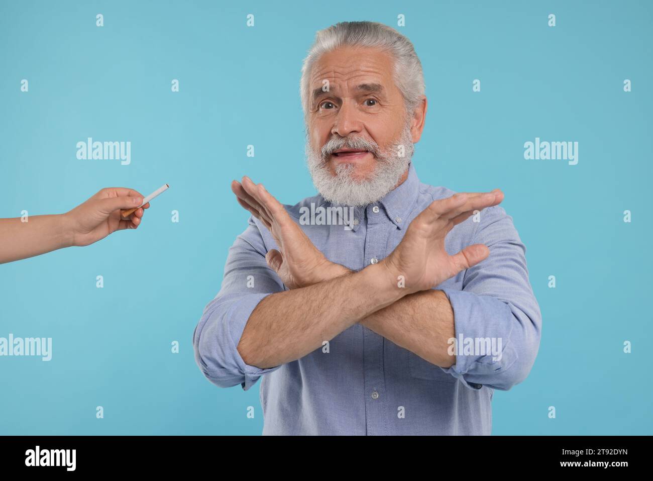 Stop smoking concept. Senior man refusing cigarette on light blue ...