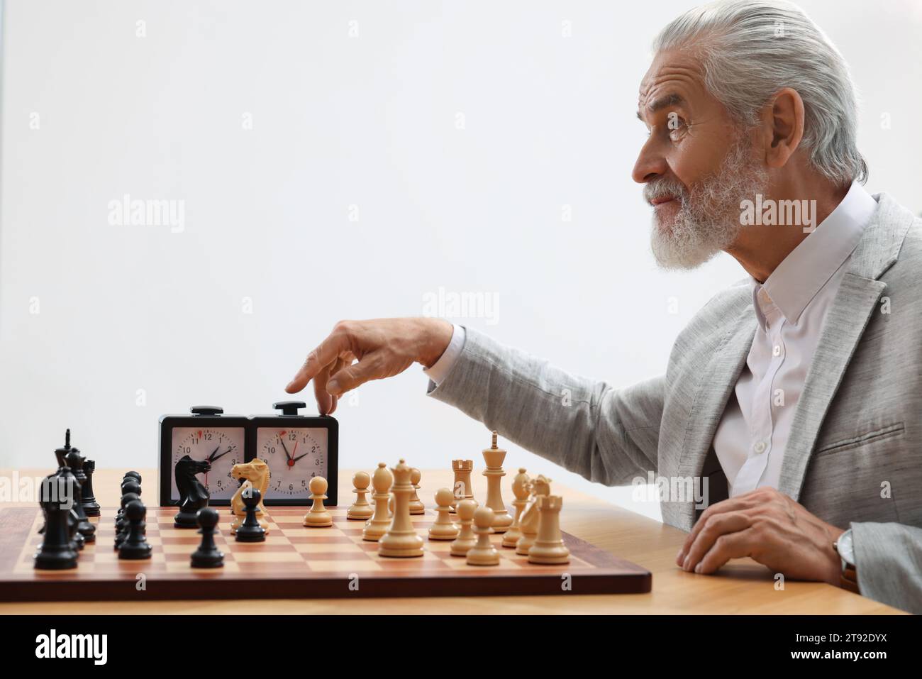 Man turning on chess clock during tournament at table against white ...