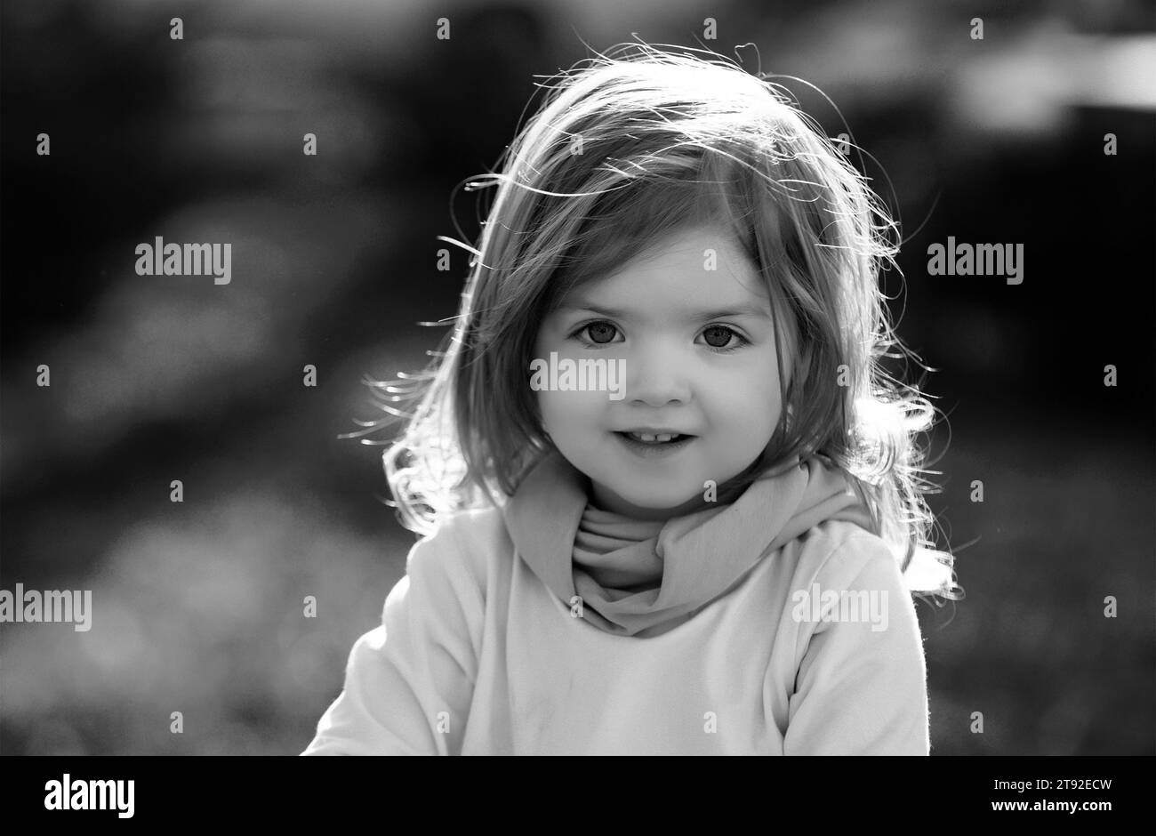 Baby child on the green grass in summer park. Baby face closeup. Funny