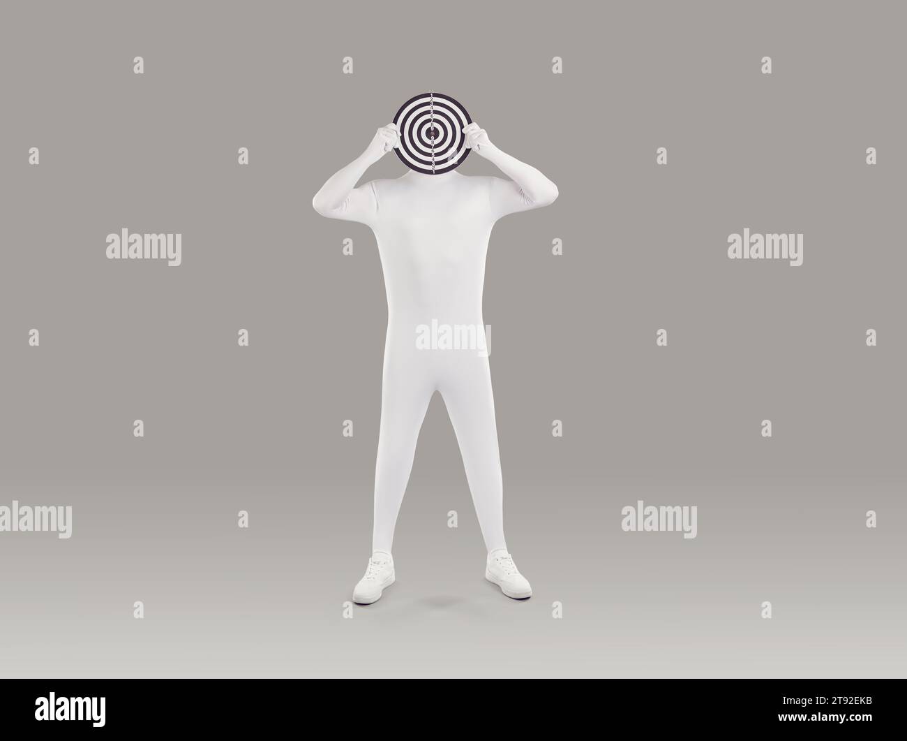 Man in white spandex bodysuit standing on grey background and holding target board Stock Photo