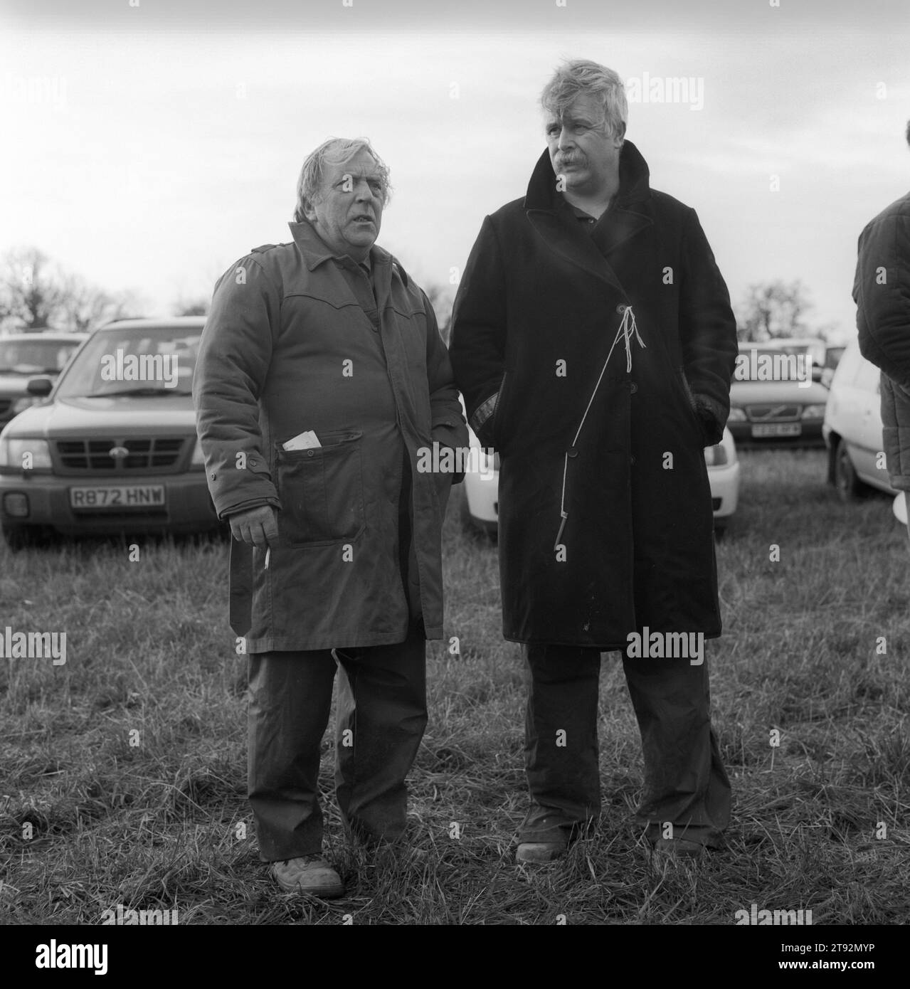 Hare Coursing. Greyhound 2000 Meet. Near Six Mile Bottom, Newmarket, Suffolk. Two working class men, the pencil on a piece of string tied to a button of his coat is so he does loose it. Pencil is used to mark his race card. 2000s England HOMER SYKES Stock Photo