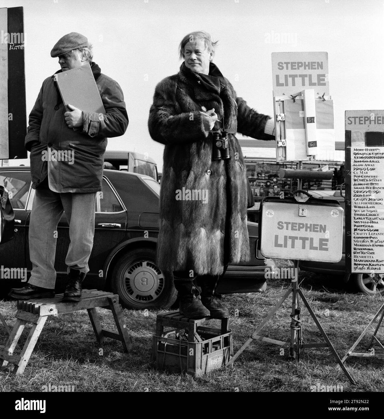 Hare Coursing UK 2000s. Stephen Little independant Rails Bookmaker taking bets on the coursing event. He wears his trademark real fur Musquash coat at the Waterloo Cup. He is with Bookies Clerk. His Bentley car in rear of image. Near Altcar, Lancashire England UK 2002  2000s HOMER SYKES Stock Photo