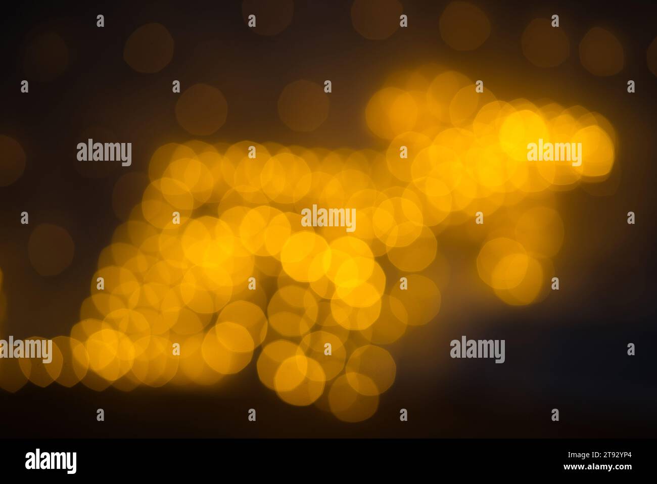 Experience the enchantment of this bokeh captured with a 75mm lens, forming a reindeer shape from closely packed glowing yellow ovals and nonagons. Th Stock Photo