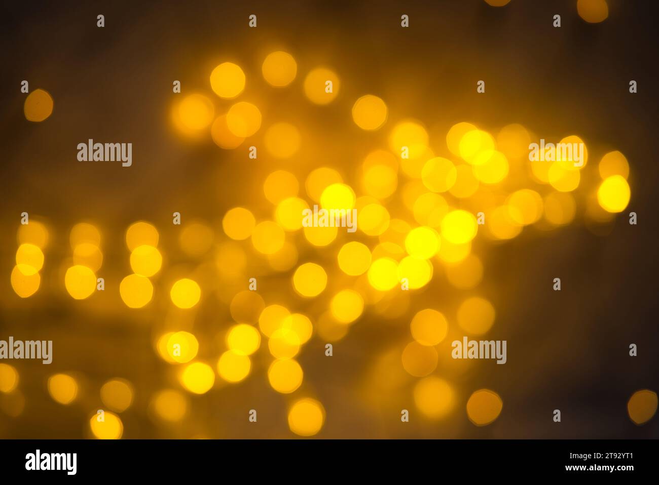 Explore the captivating play of lights with this bokeh image featuring medium-sized nonagons arranged asymmetrically across the frame. The lights, in Stock Photo