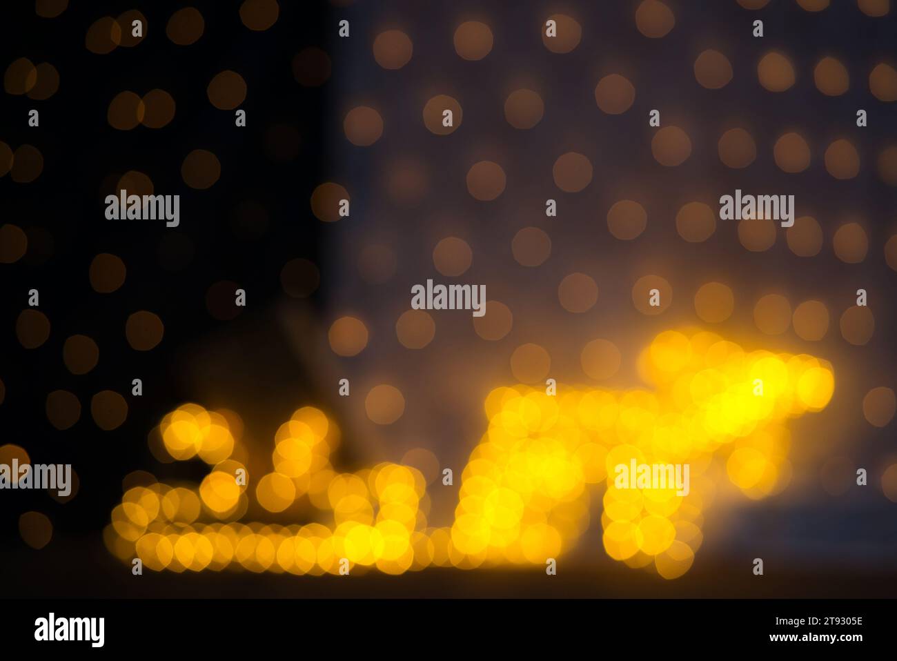 Immerse yourself in the enchanting atmosphere of this festive bokeh, captured with a 75mm lens on a full-frame camera. The image features a blurred ye Stock Photo