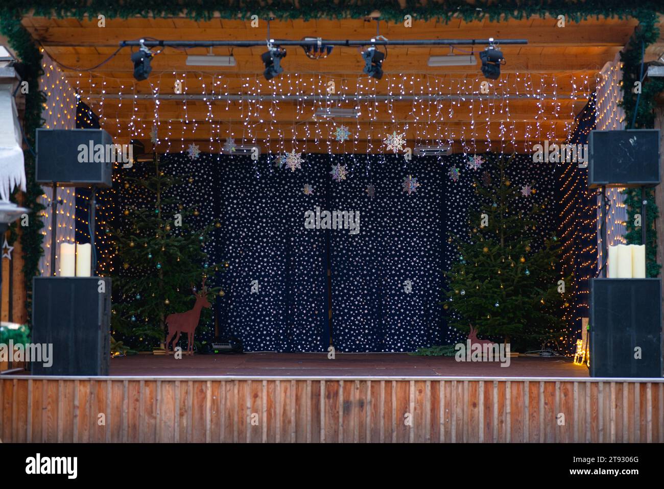 Step into a charming Christmas scene with a small stage adorned with a sound system. The focal point is the stage backdrop, featuring blue fabric with Stock Photo