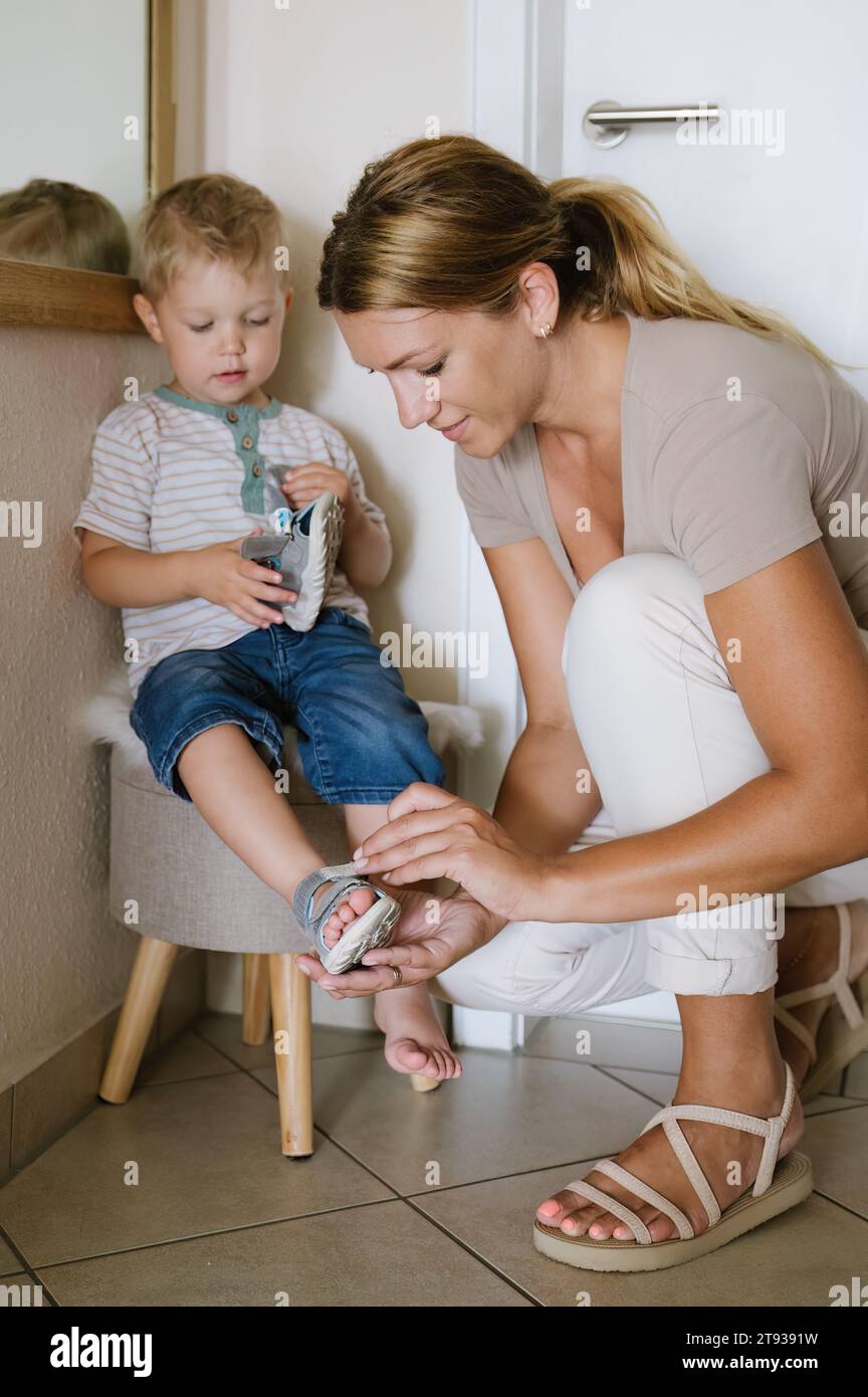 Side view of young mother looking down while sitting near playing