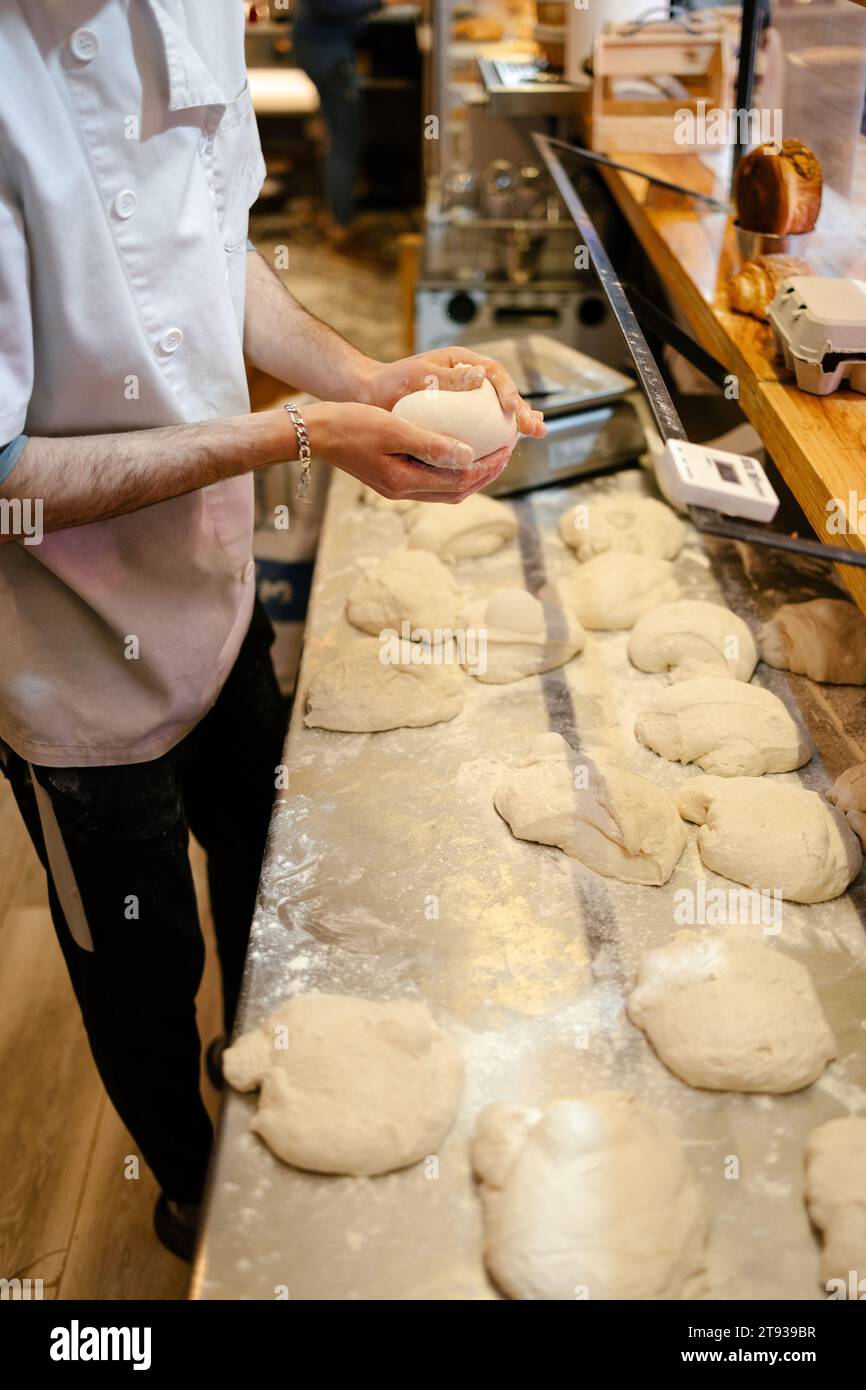 Detail shot of an unrecognizable baker's hands while kneading manually