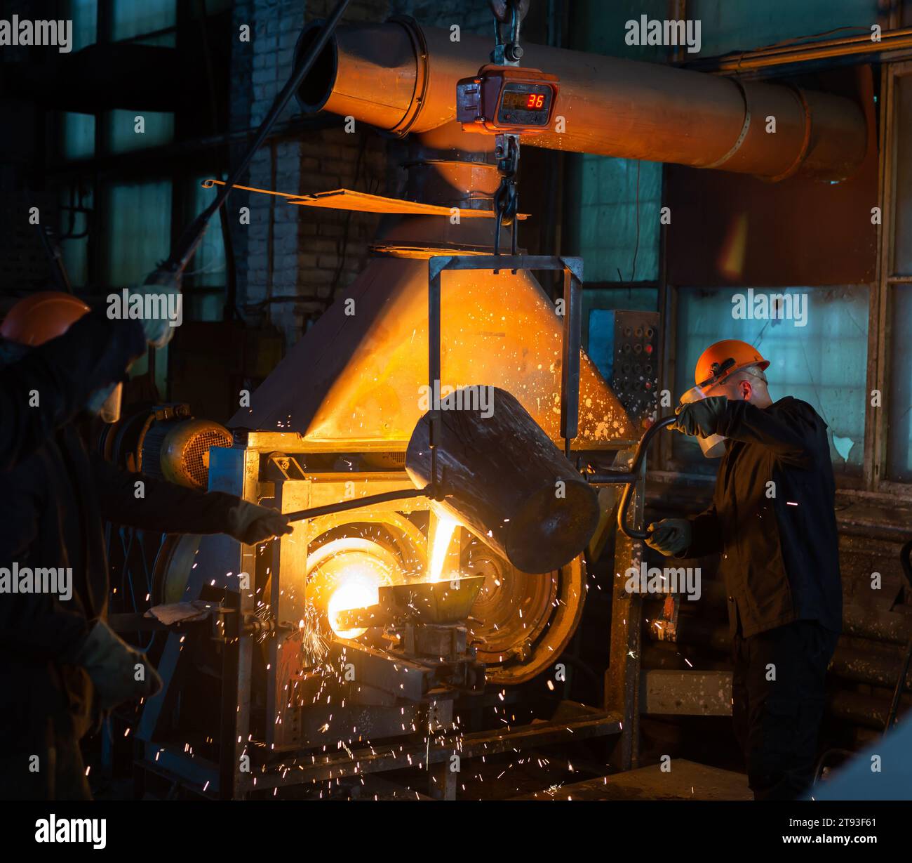 Pouring molten metal into a centrifugal machine in the foundry shop of metallurgical plant Stock Photo