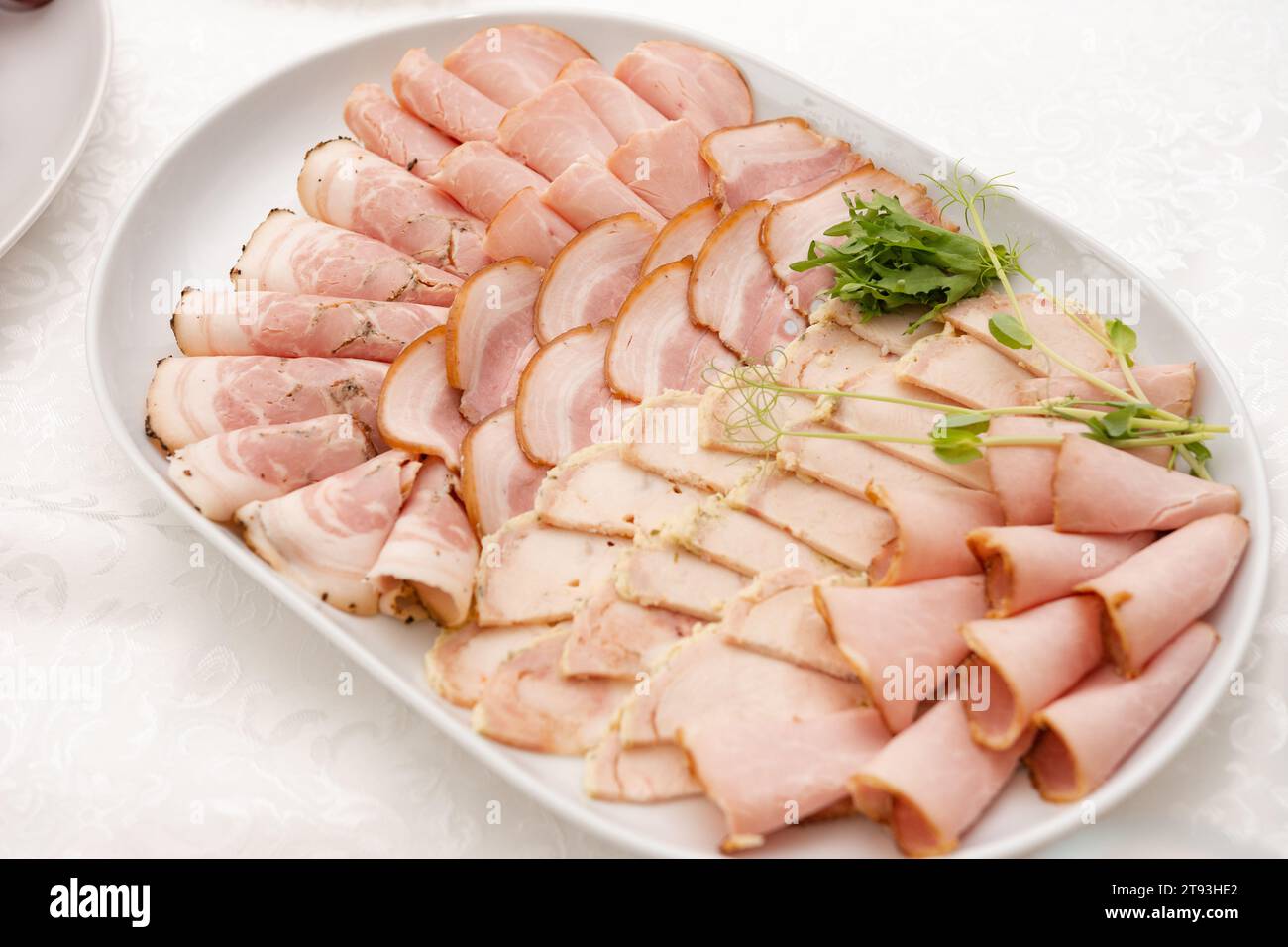 Meat cutting and its presentation on the festive table, ham meat appetizer. Stock Photo