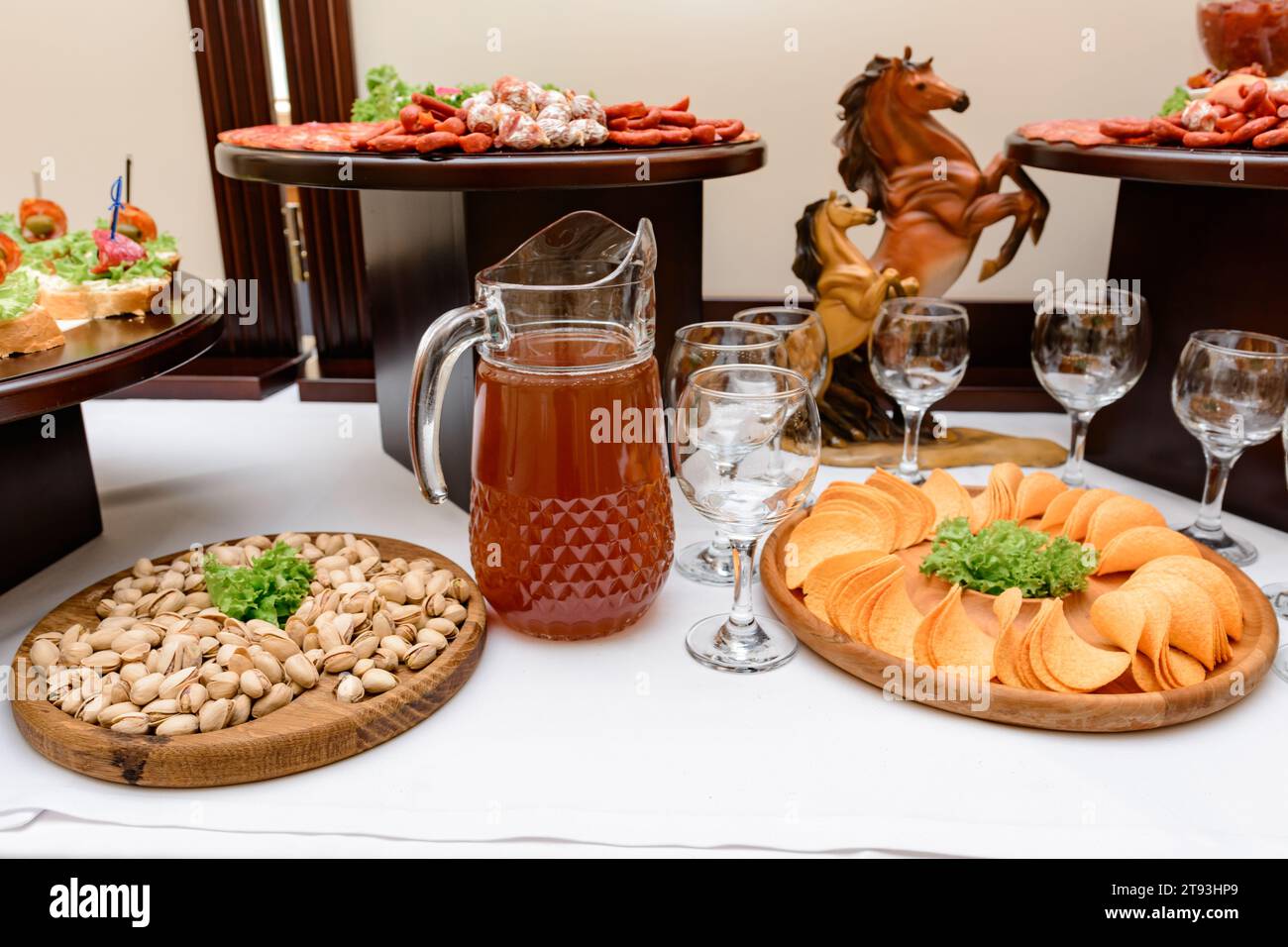 Alcoholic drinks on the buffet table during the celebration of the event, chips and pistachios for a snack. Stock Photo