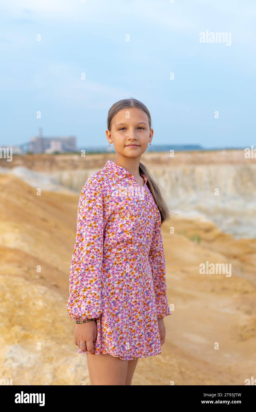 A teenage girl with long hair tied up in a ponytail in a short dress