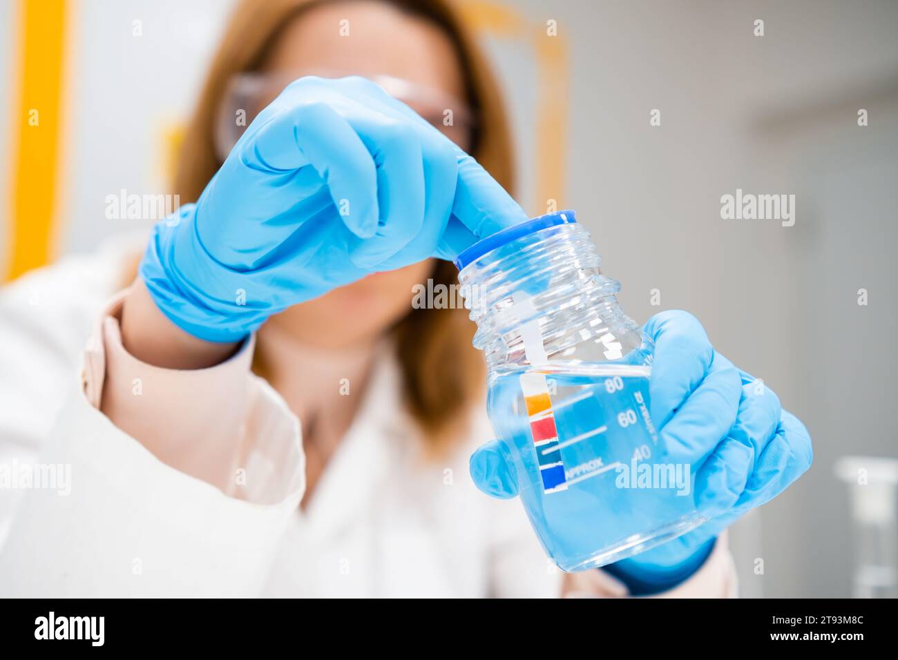 Scientist inserts a indicator paper into the solution, measurement of pH. Stock Photo