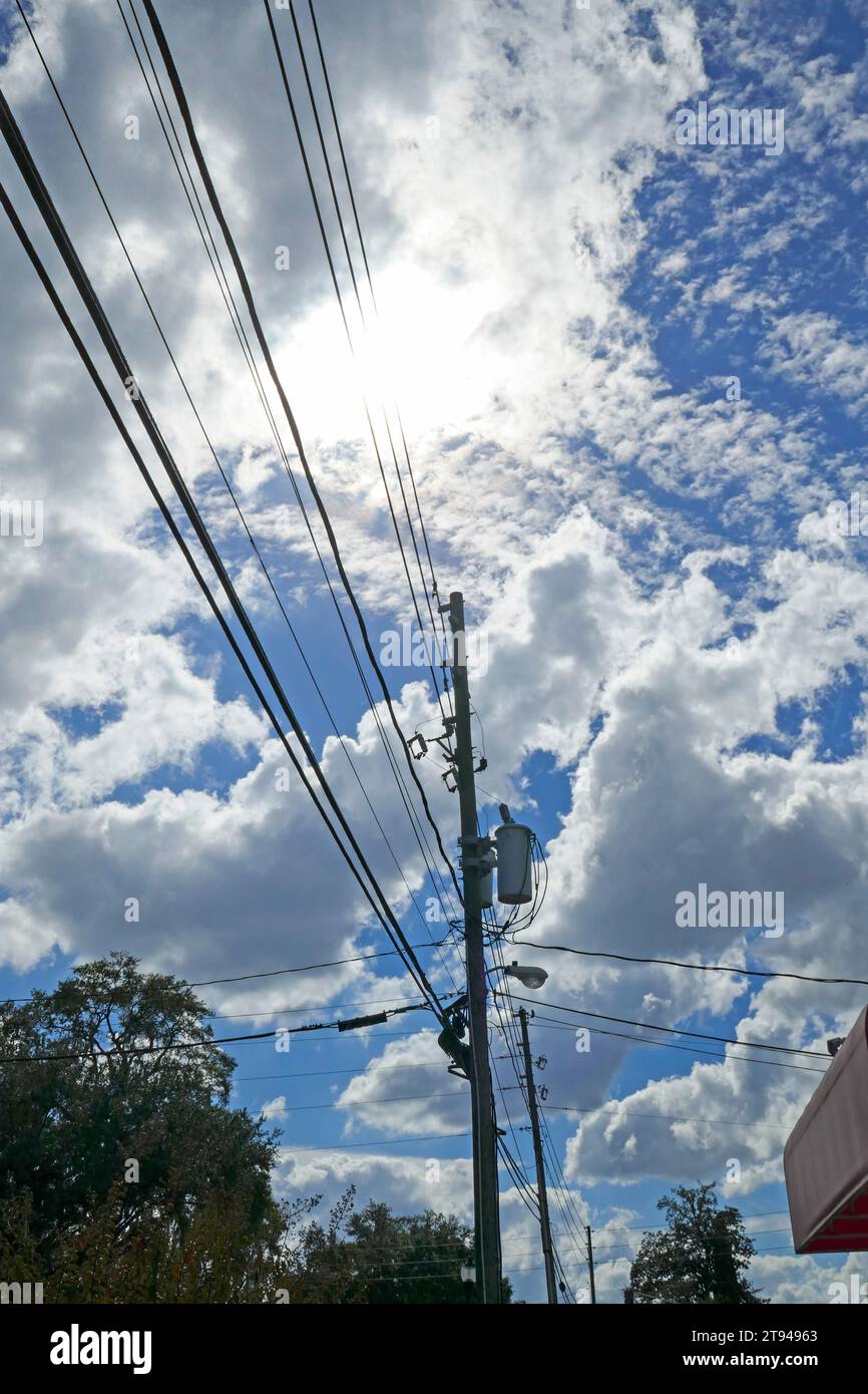 Power lines against a beautiful fall sky with puffy white clouds. Stock Photo