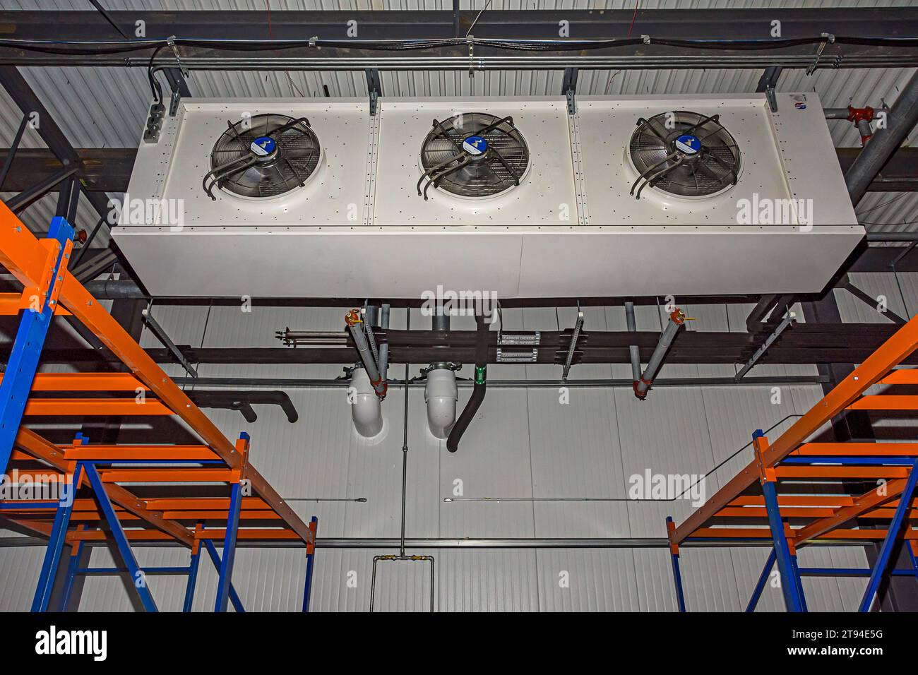 An evaporator and piping near the ceiling in the freezer of a cold-storage (industrial refrigeration) warehouse. Stock Photo