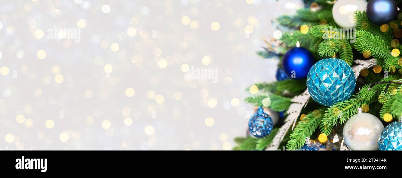 Holiday Christmas tree with ornaments and balls on golden background with bokeh lights. Merry Christmas and a happy New Year greeting card. Winter hol Stock Photo