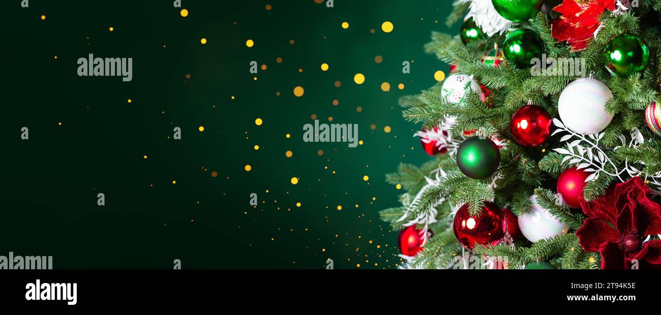 Christmas tree with ornaments, balls and lights on dark green background. Merry Christmas and a happy New Year greeting card. Winter holiday backgroun Stock Photo