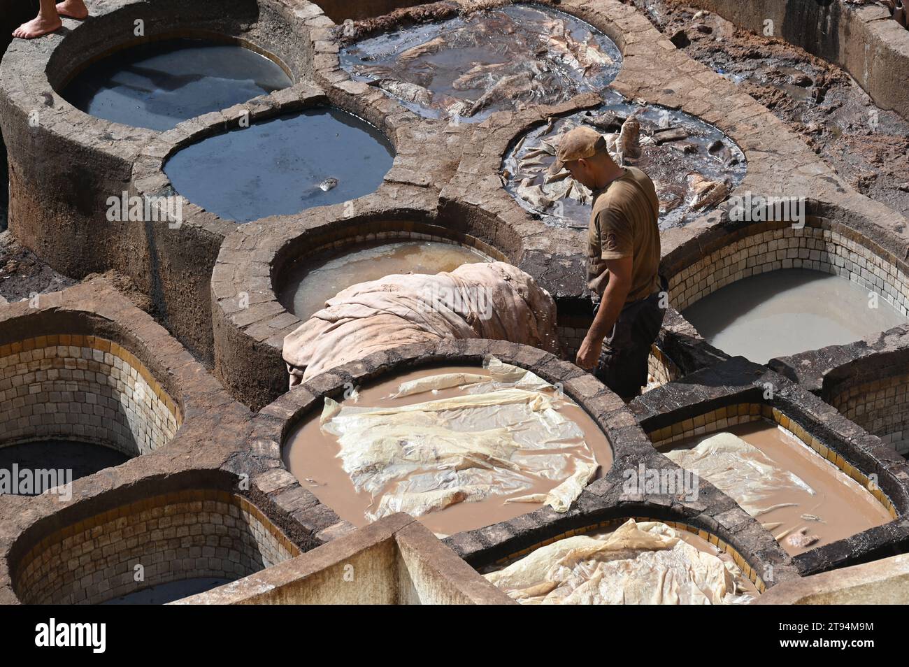 Workers in the historic tanning pools in Fez. Medieval-looking working ...