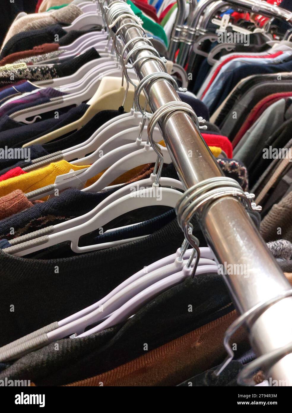 many clothes hanging on hangers in used clothing store Stock Photo Alamy