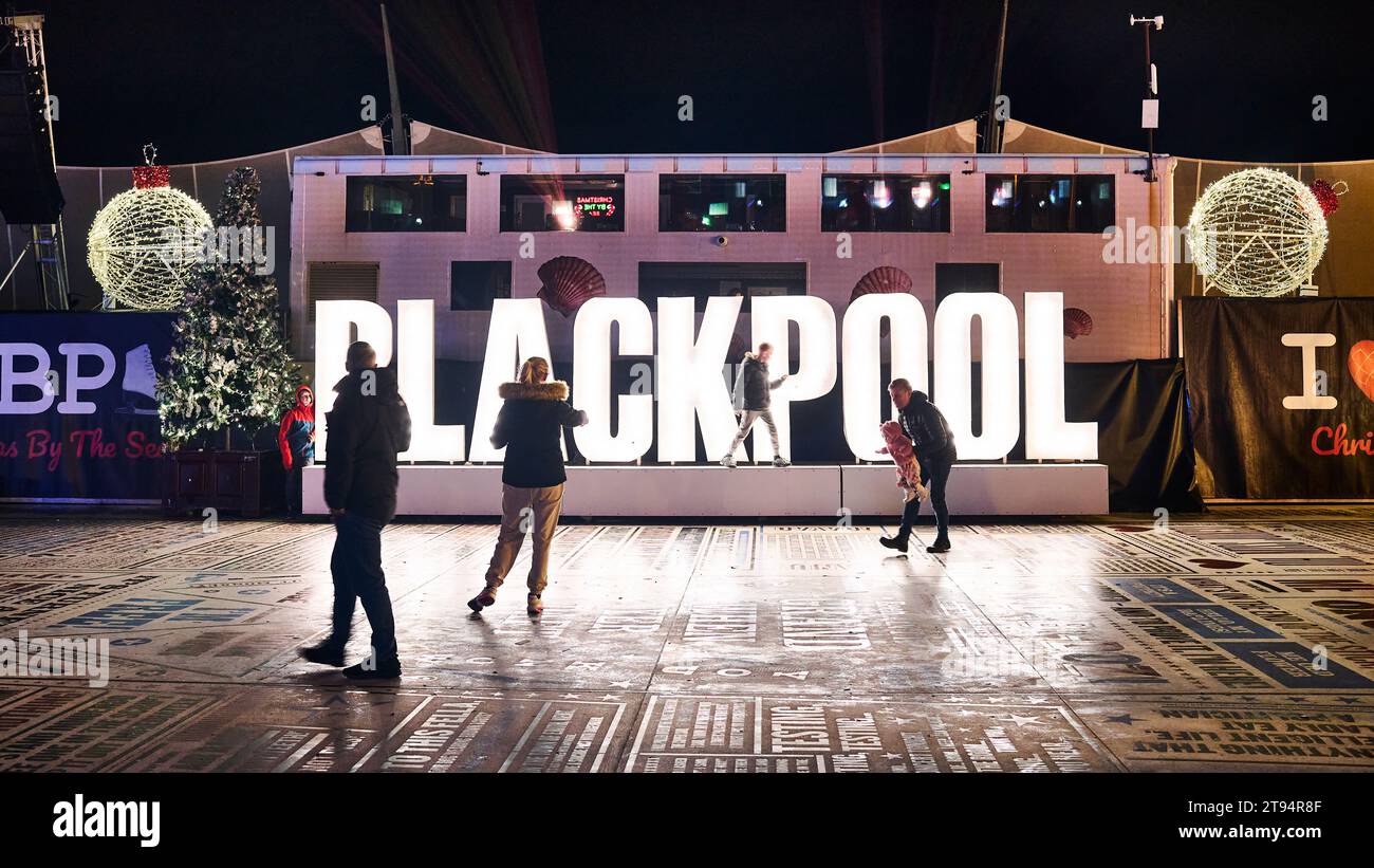 Families gather and play around the illuminated Blackpool sign at the Blackpool Christmas market and  fair 2023 on the Tower festival headland. Stock Photo