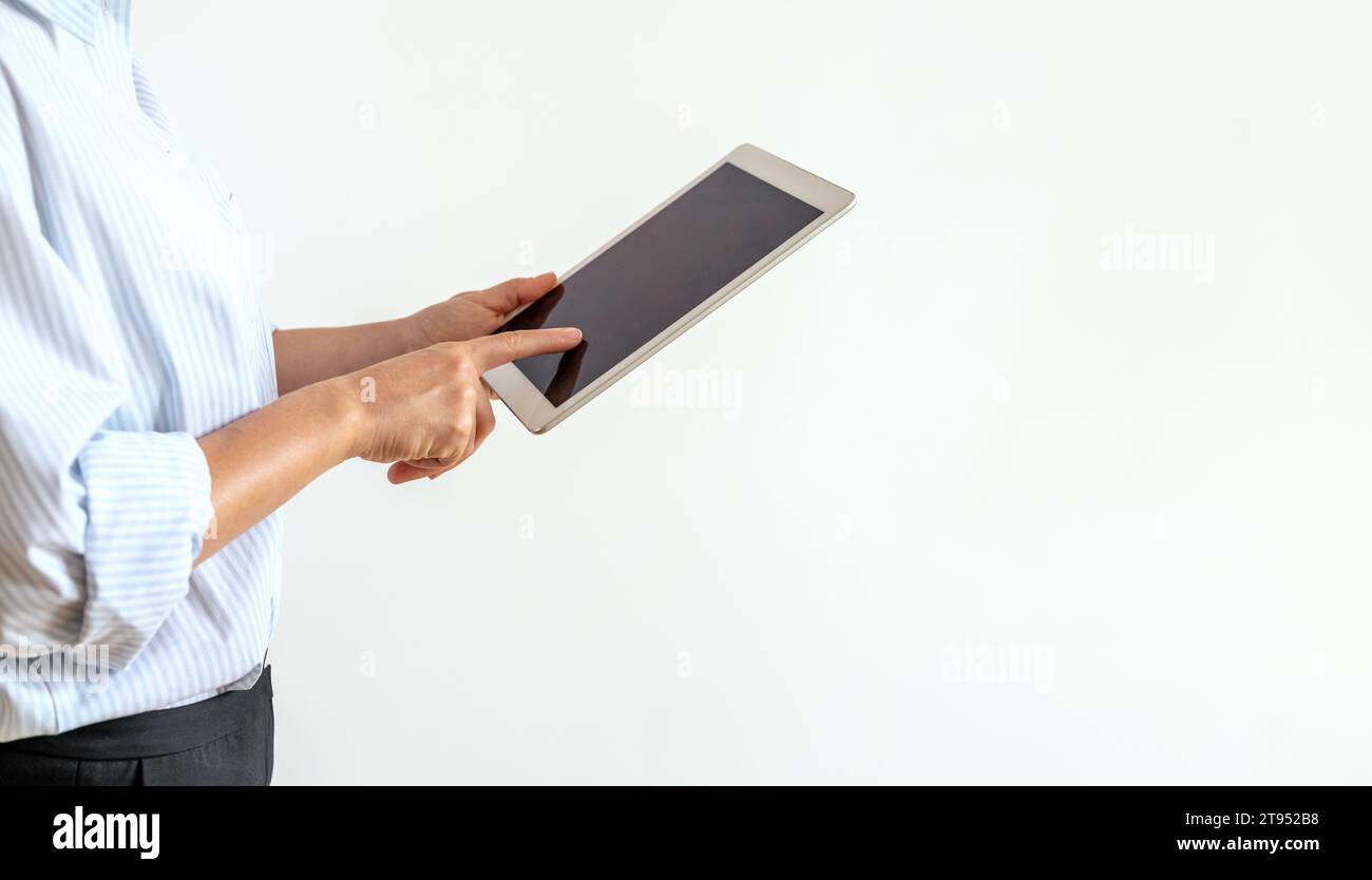 Isolated businesswoman using computer tablet, touching screen of digital tablet with finger. Stock Photo