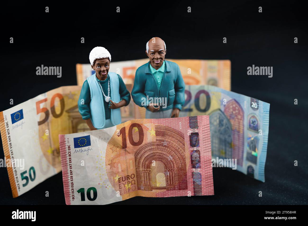 black senior couple with Euro coin, retirement pay Stock Photo