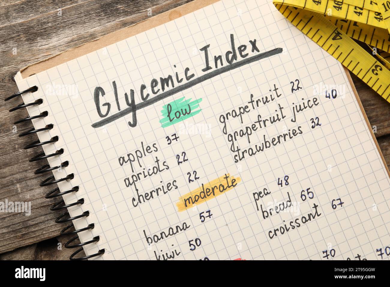 List with products of low and moderate glycemic index in notebook on wooden table, top view Stock Photo